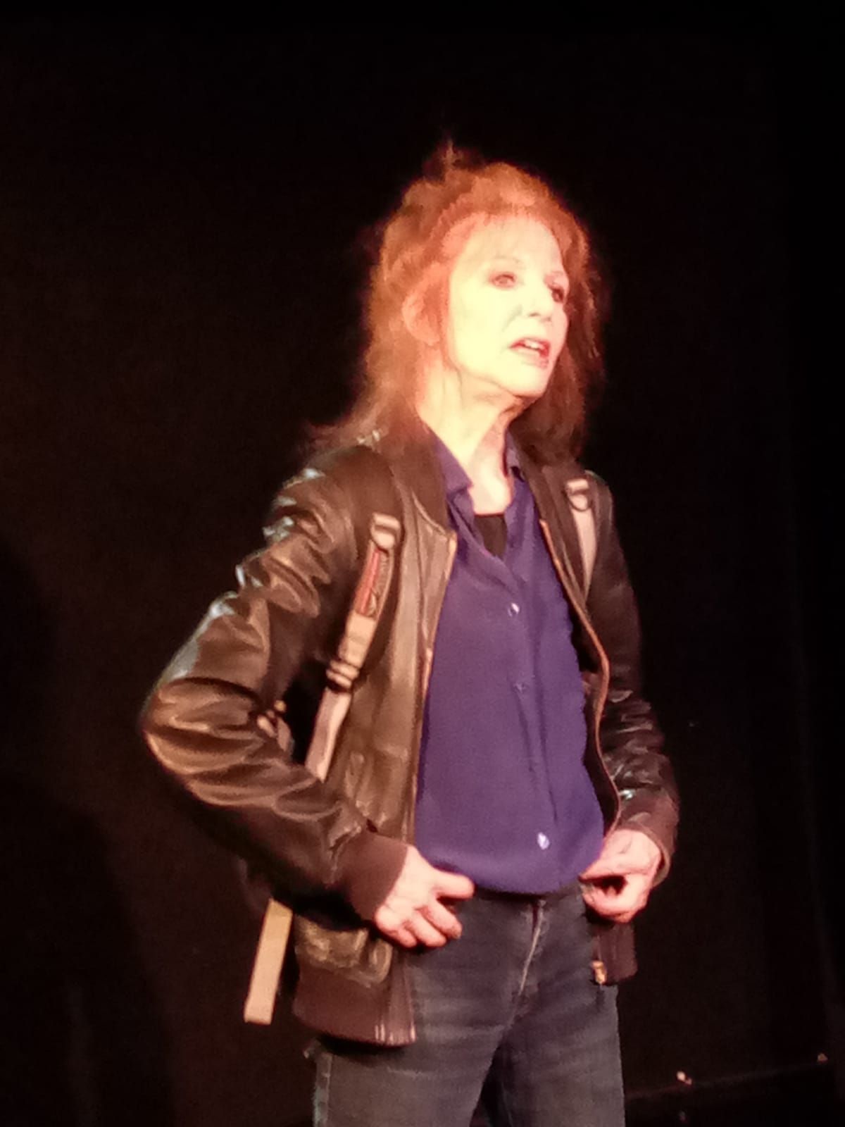 Une femme portant une veste en cuir noir et une chemise bleue