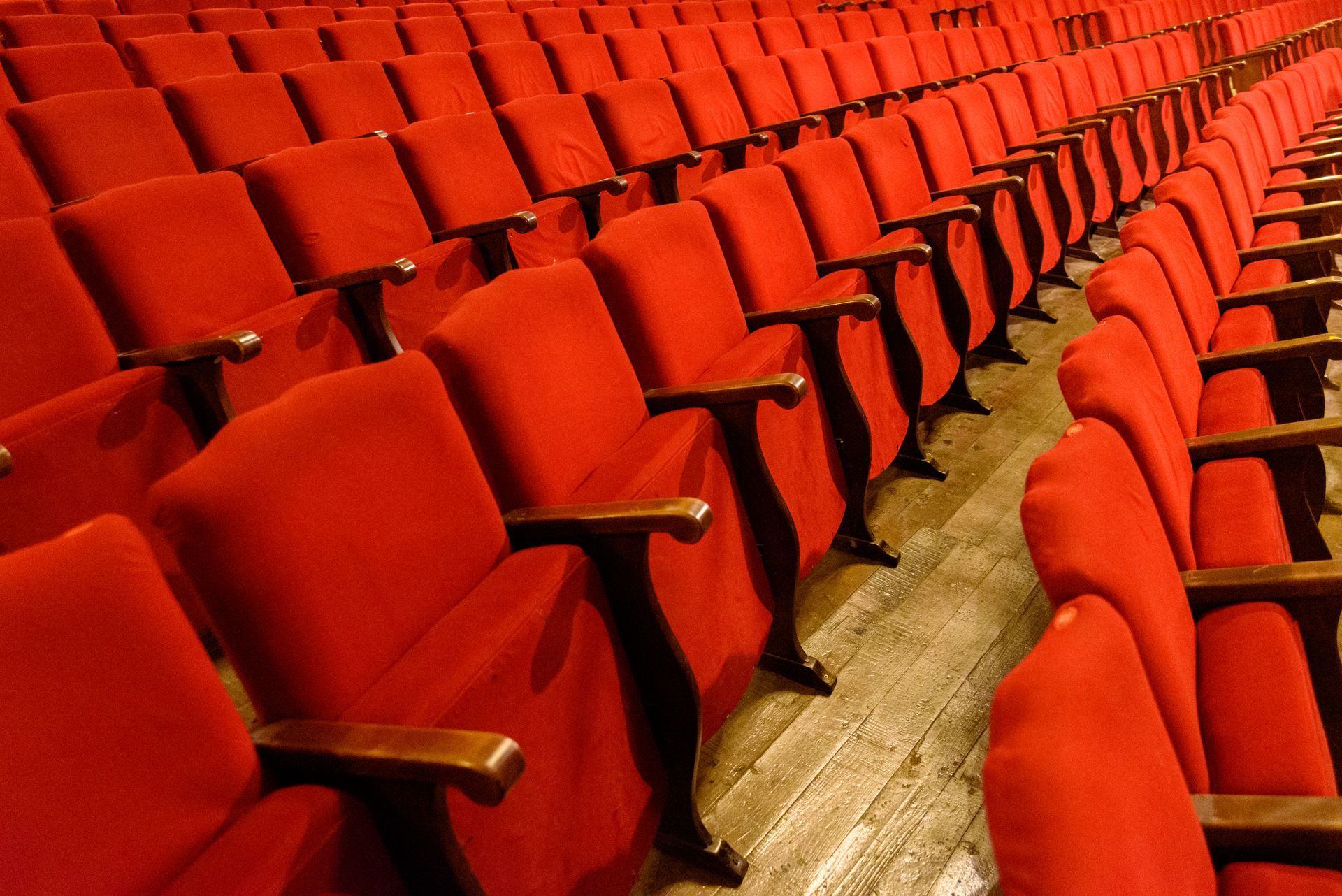 rangées de chaises rouges dans un auditorium avec parquet