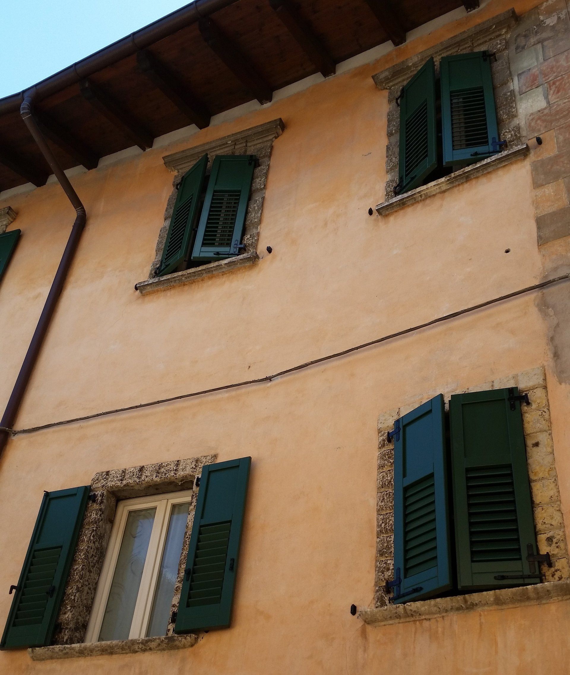 edificio con facciata arancione e persiane verdi