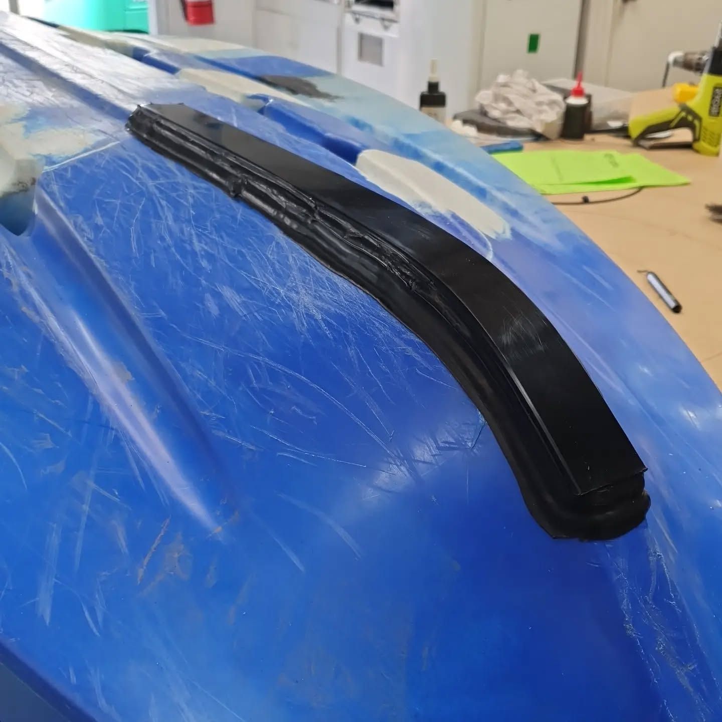 A Blue Kayak is Sitting on a Wooden Table — Coastal Plastics In Tweed Heads South, NSW