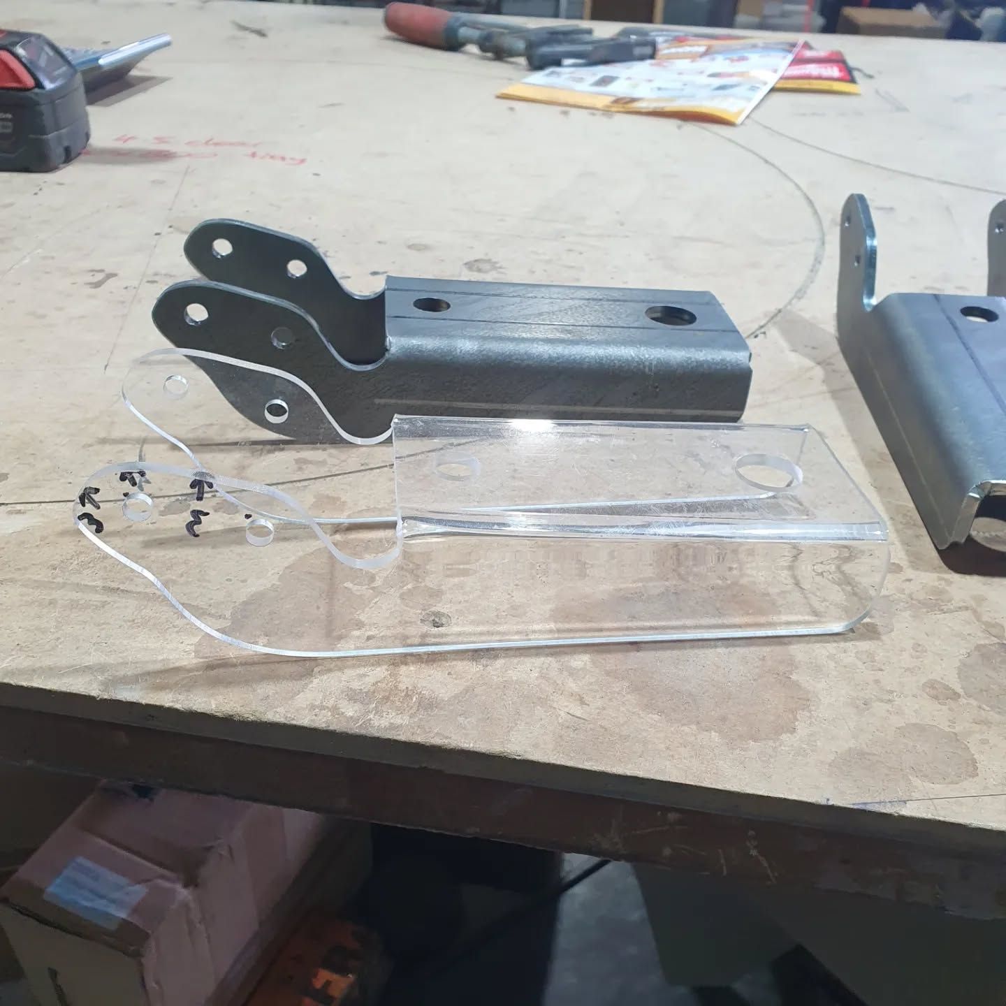 A Piece of Clear Plastic is Sitting on a Wooden Table — Coastal Plastics In Tweed Heads South, NSW