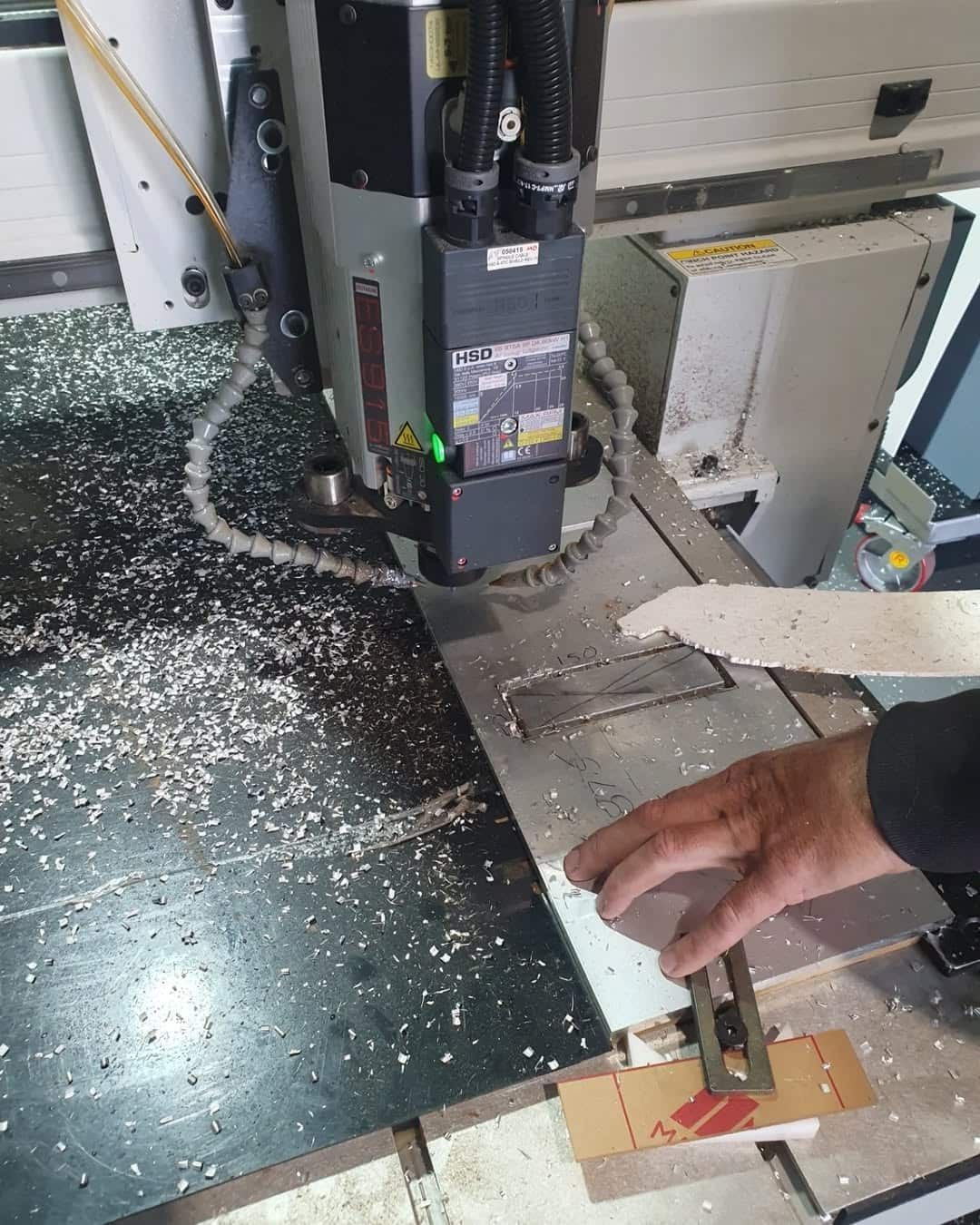 A Person is Using a Machine to Cut a Piece of Wood — Coastal Plastics In Tweed Heads South, NSW