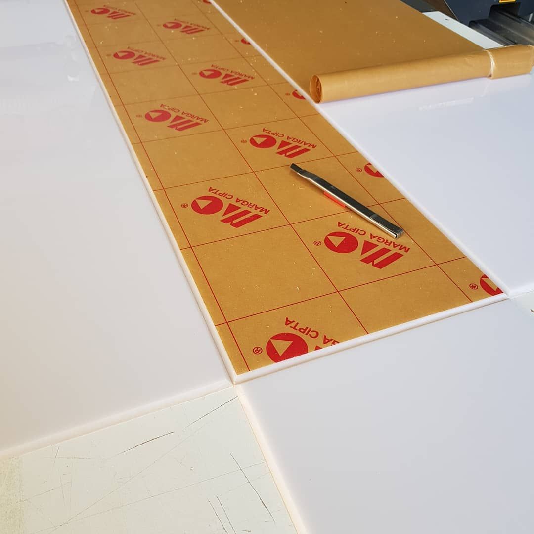 A Piece of Acrylic is Laying on a Table Next to a Pen — Coastal Plastics In Tweed Heads South, NSW