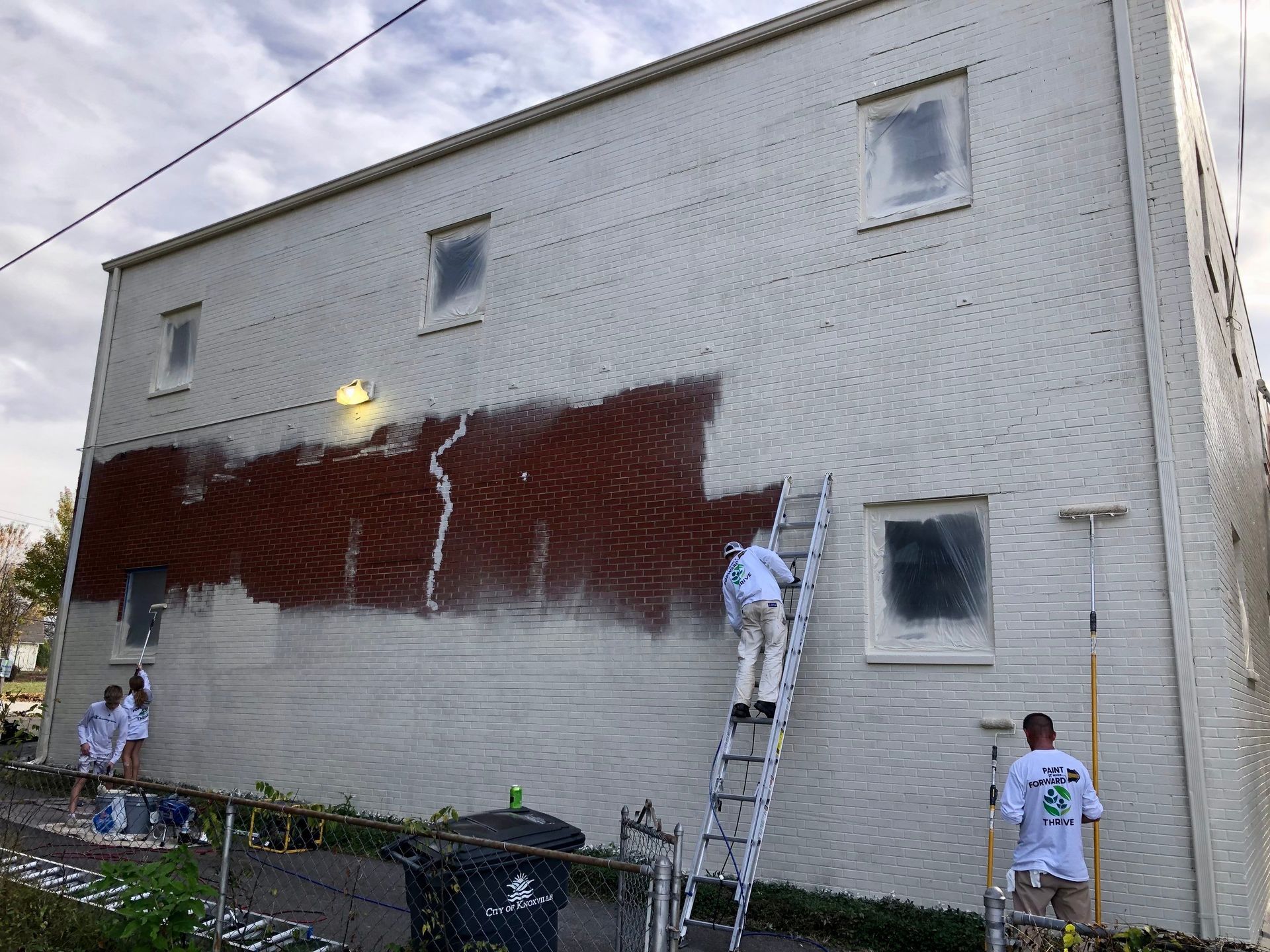A group of people are painting the side of a building.