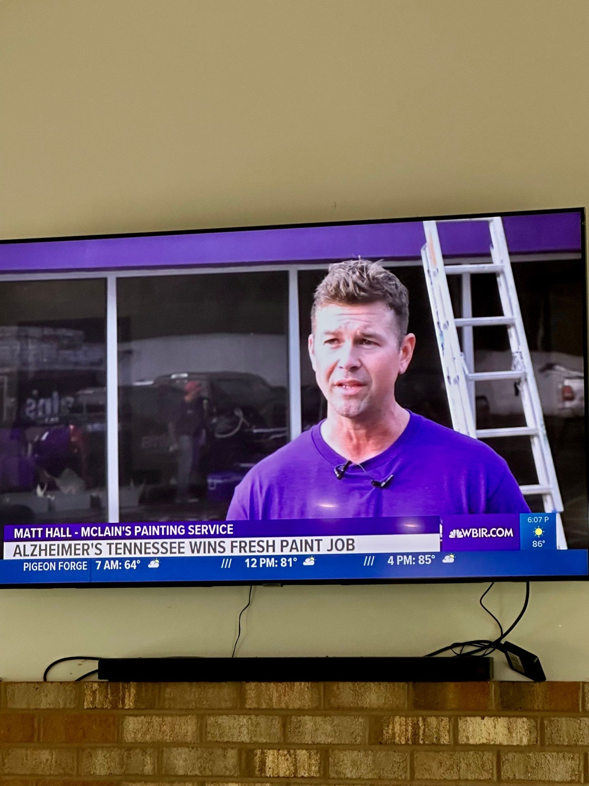 A man is standing in front of a ladder on a television screen.