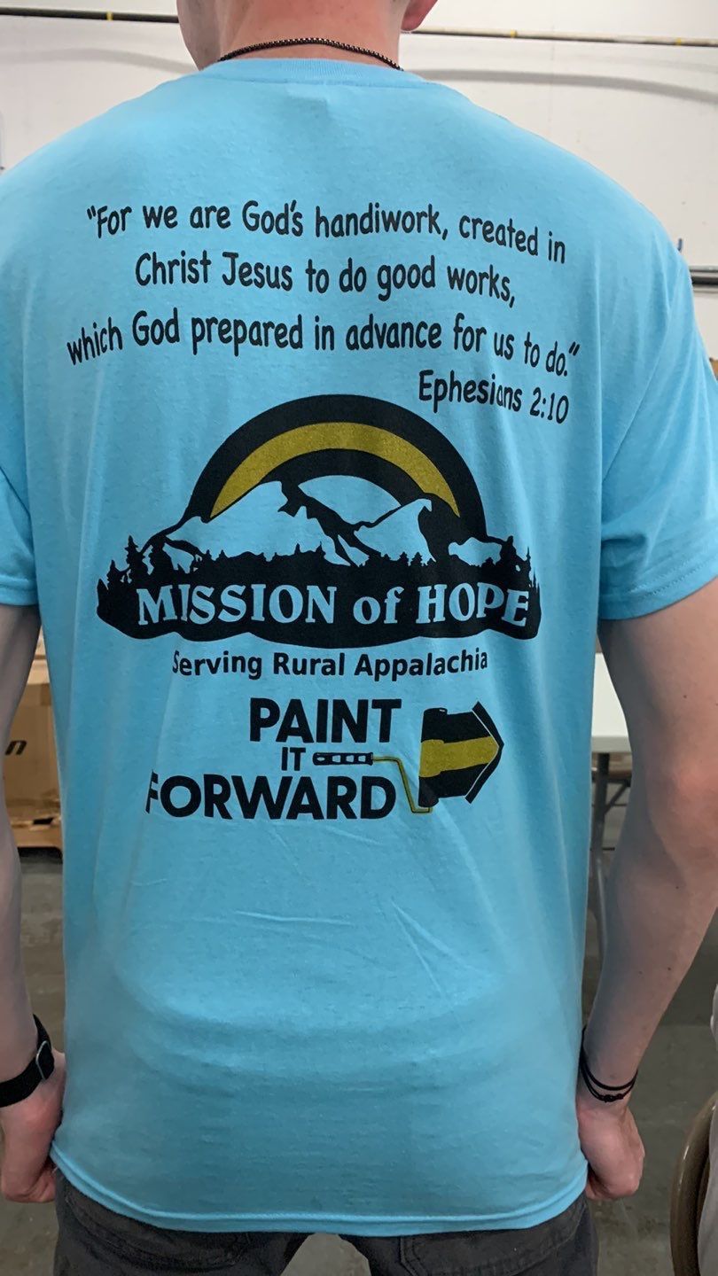 A man is wearing a blue mission of hope t-shirt.