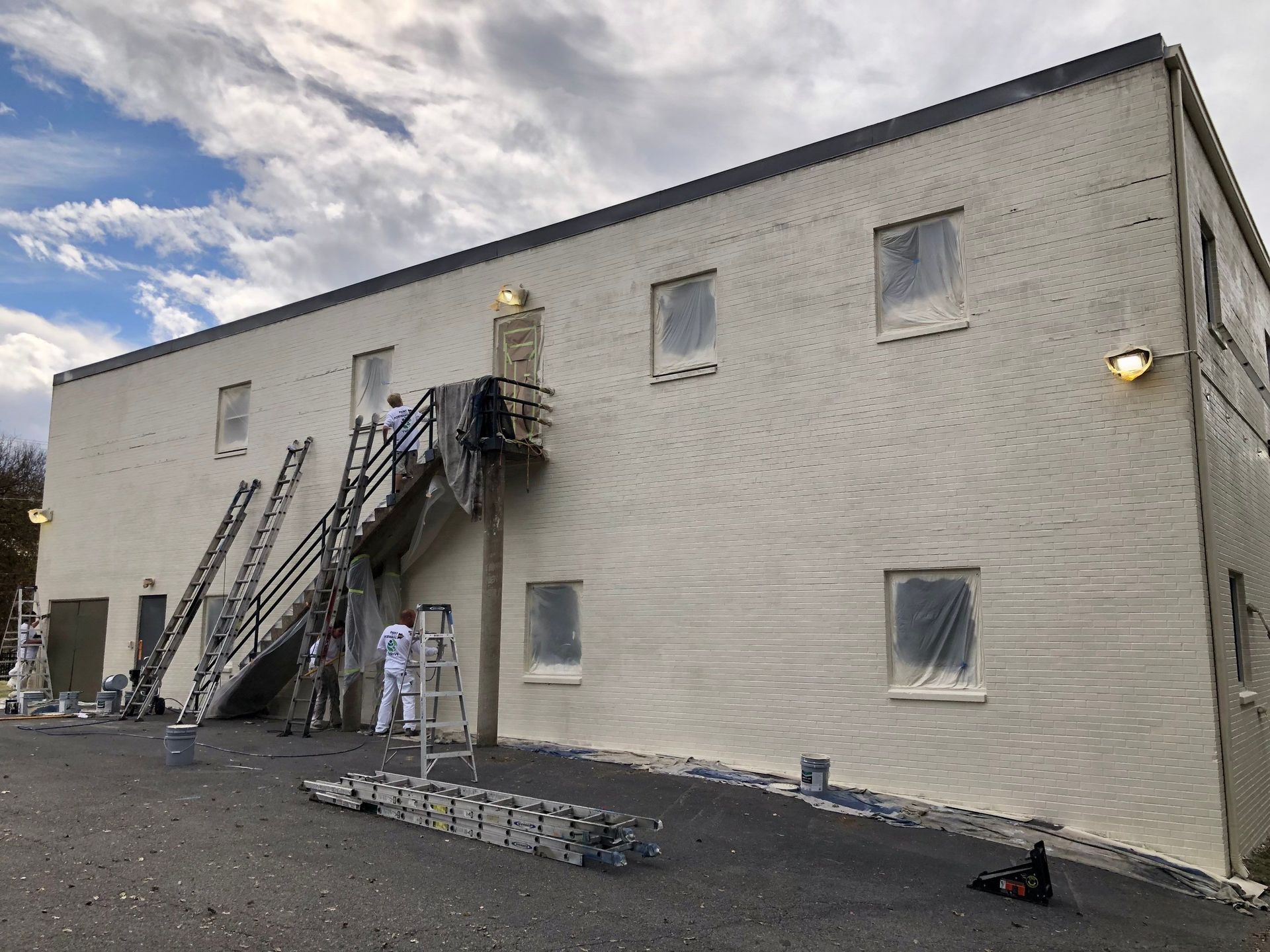 A group of people are painting the side of a building.