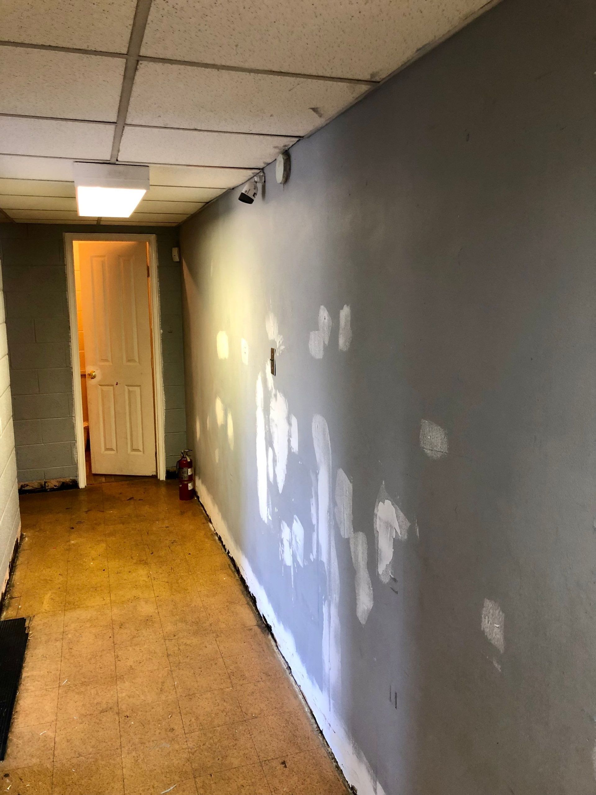 A hallway with a door and a gray wall