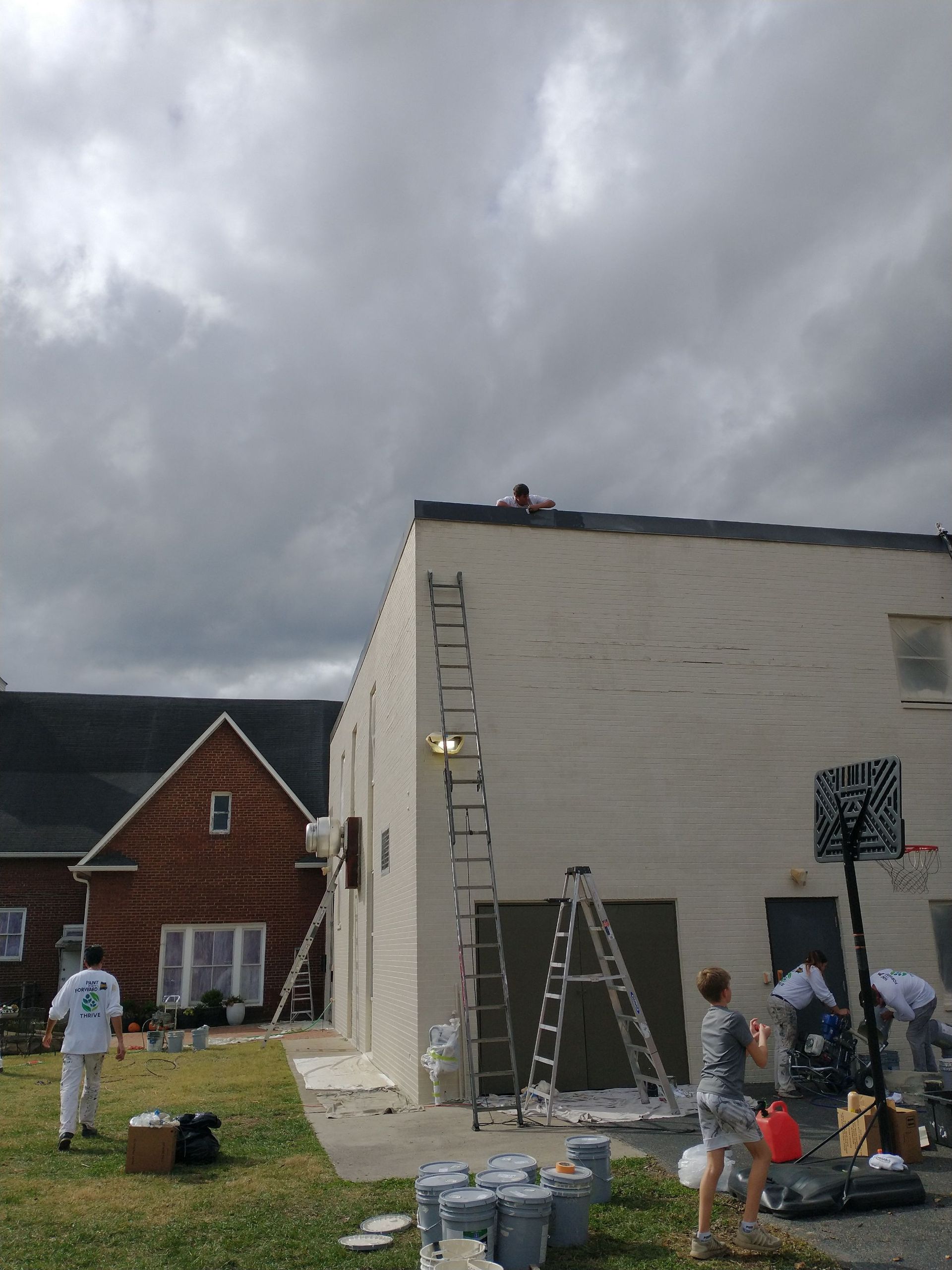 A group of people are painting the side of a building