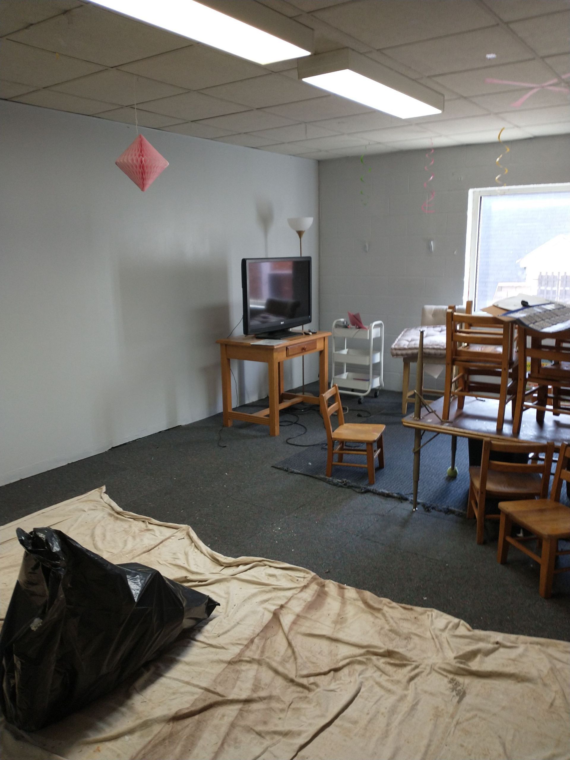 A room with tables and chairs and a flat screen tv