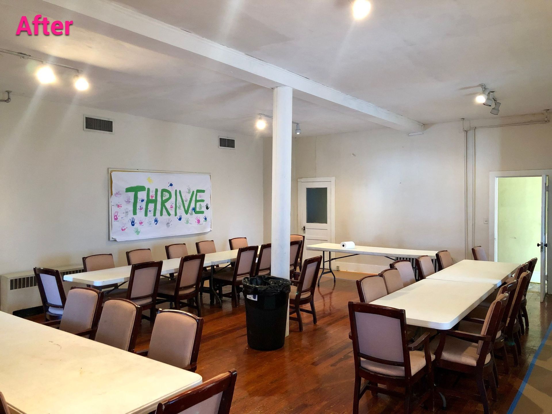 A room with tables and chairs and a sign that says thrive