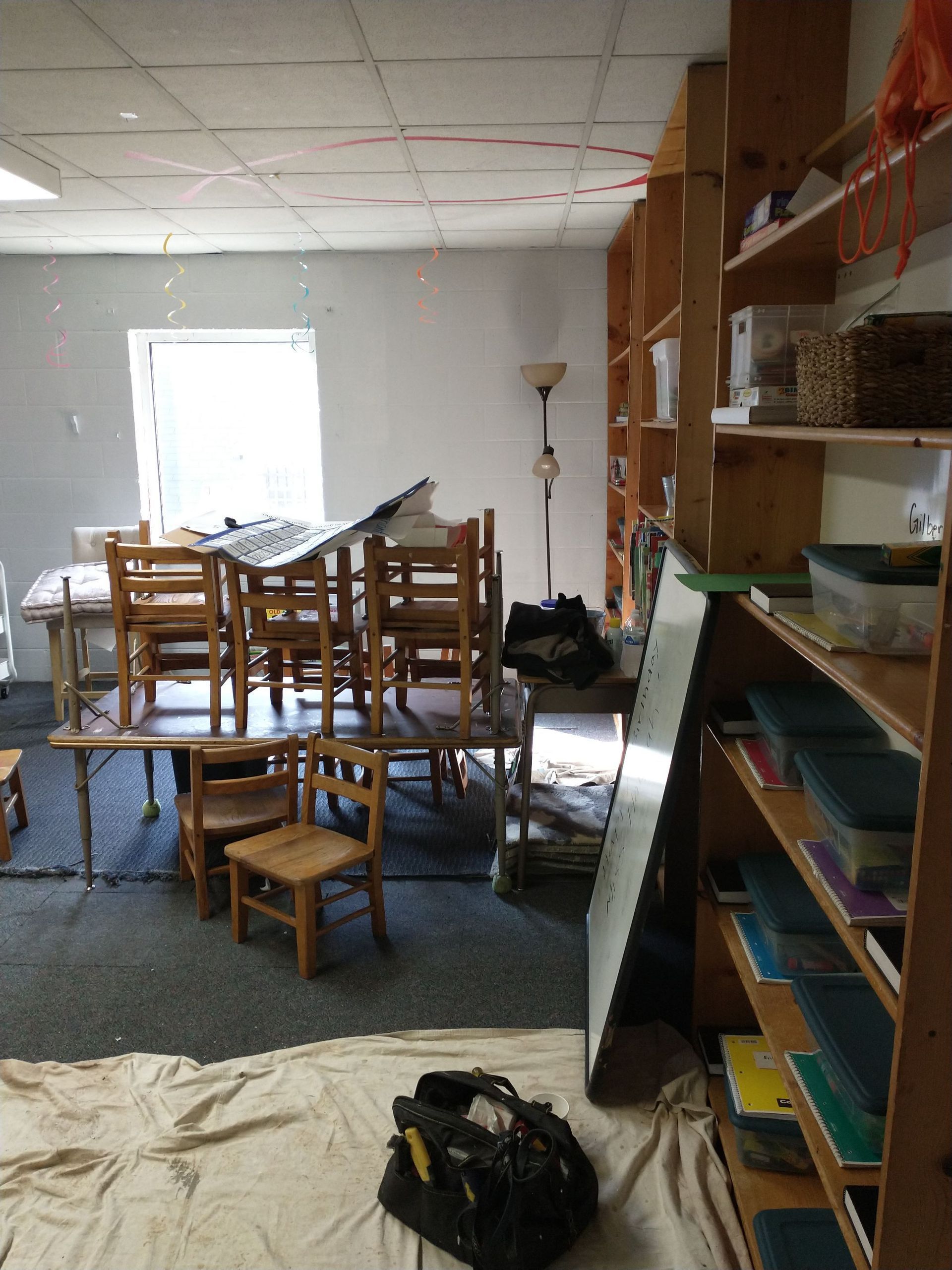 A room with tables and chairs and a bag on the floor