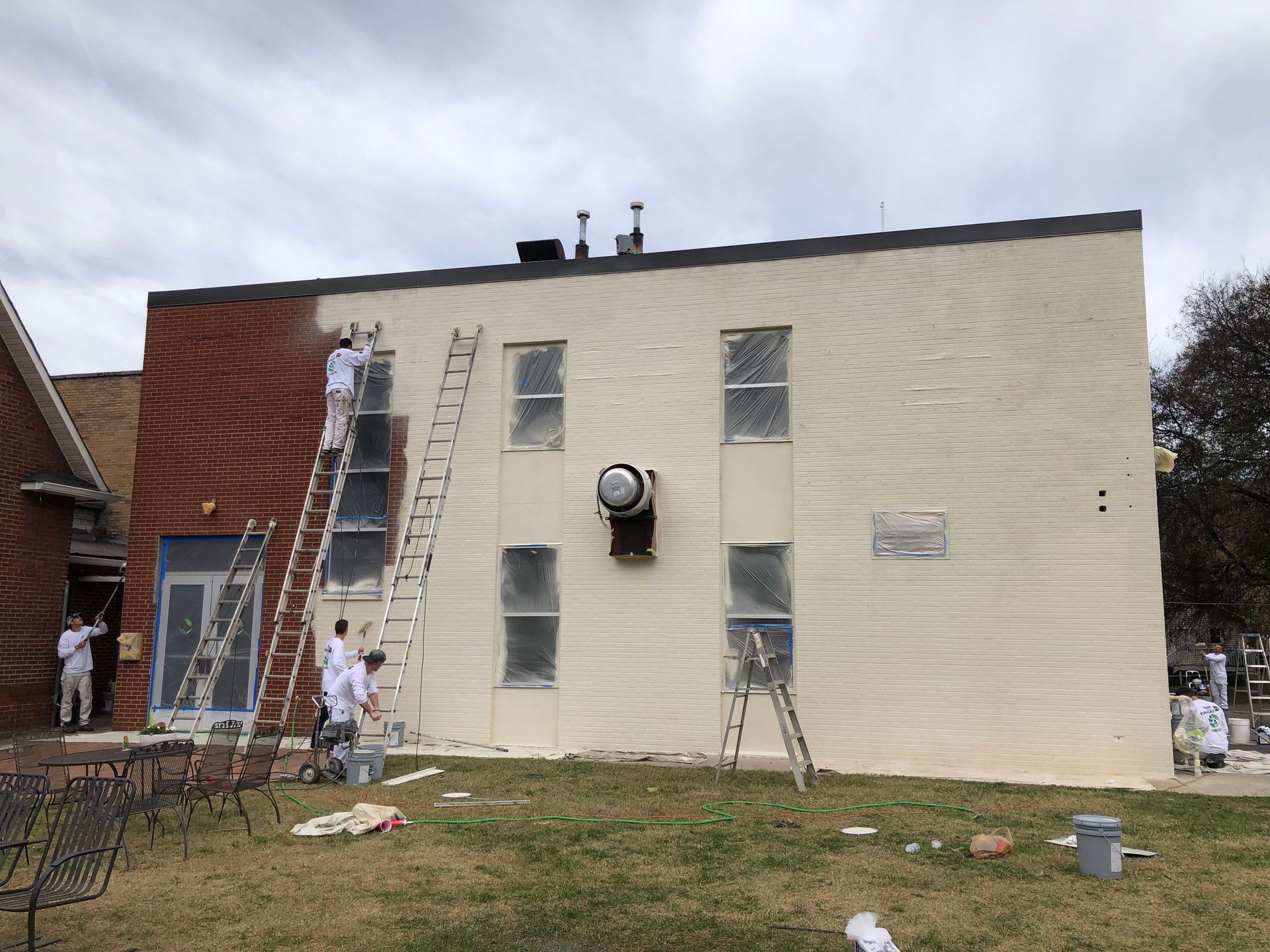 A group of people are painting the side of a building.