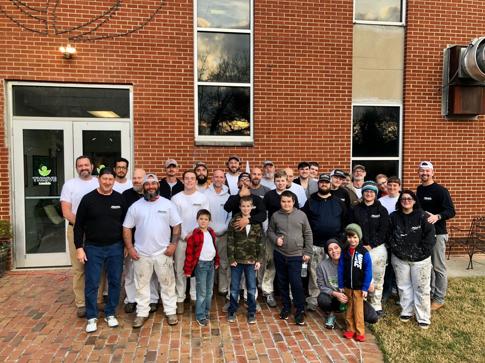 A group of people are posing for a picture in front of a brick building.