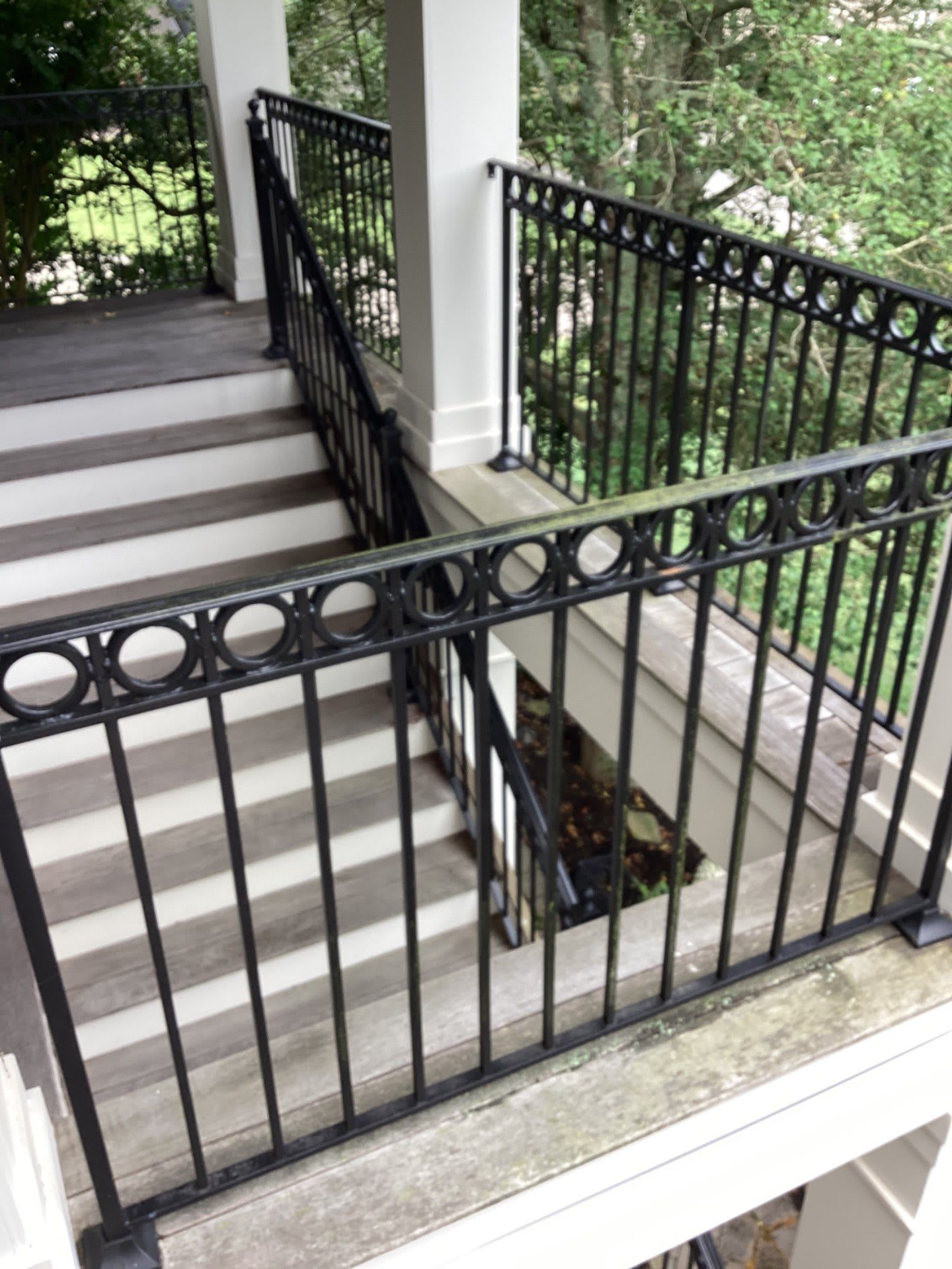 A balcony with stairs and a black railing