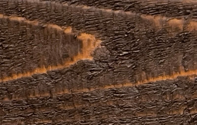 A close up of a piece of wood with a yellow stripe on it.