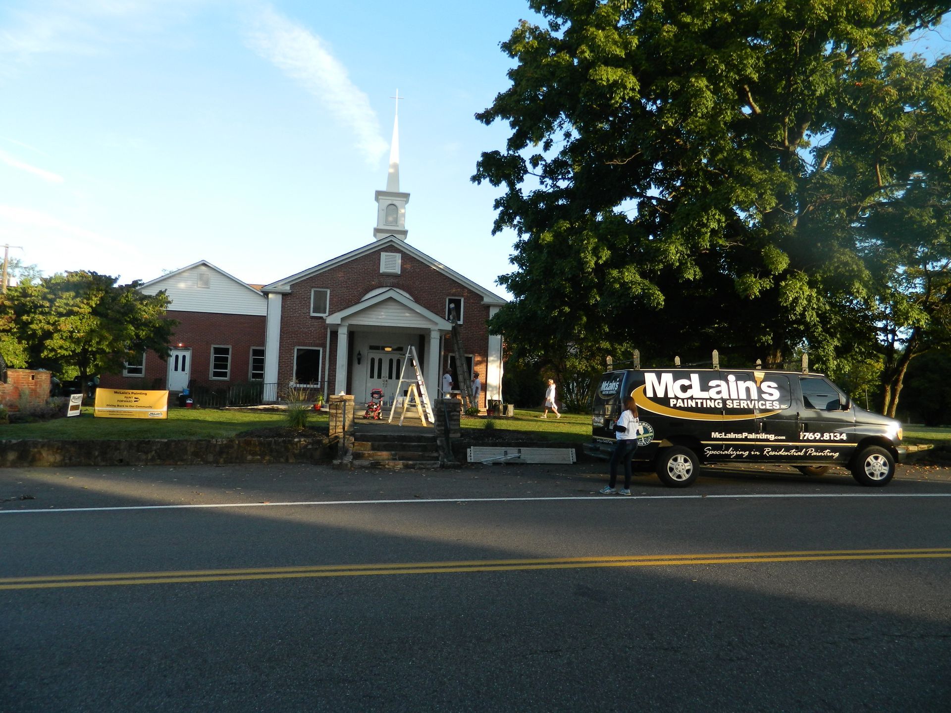 A mclain 's truck is parked in front of a church