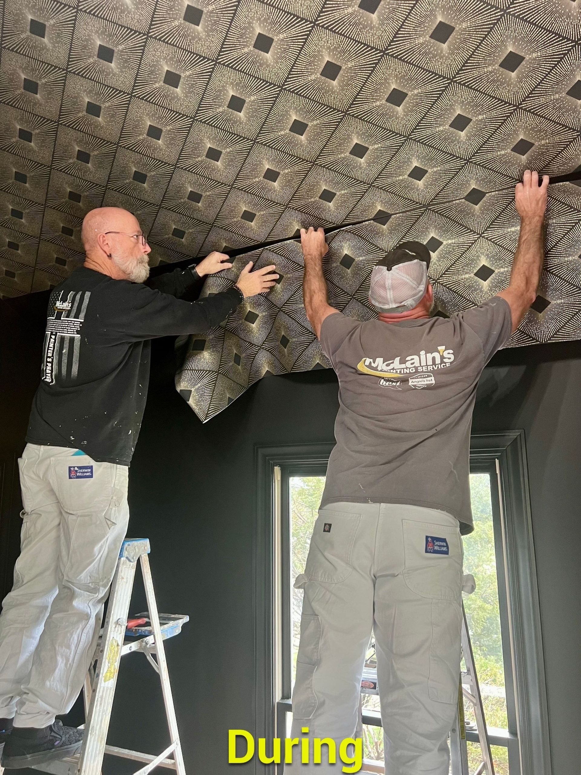 Two men are standing on a ladder working on a ceiling.