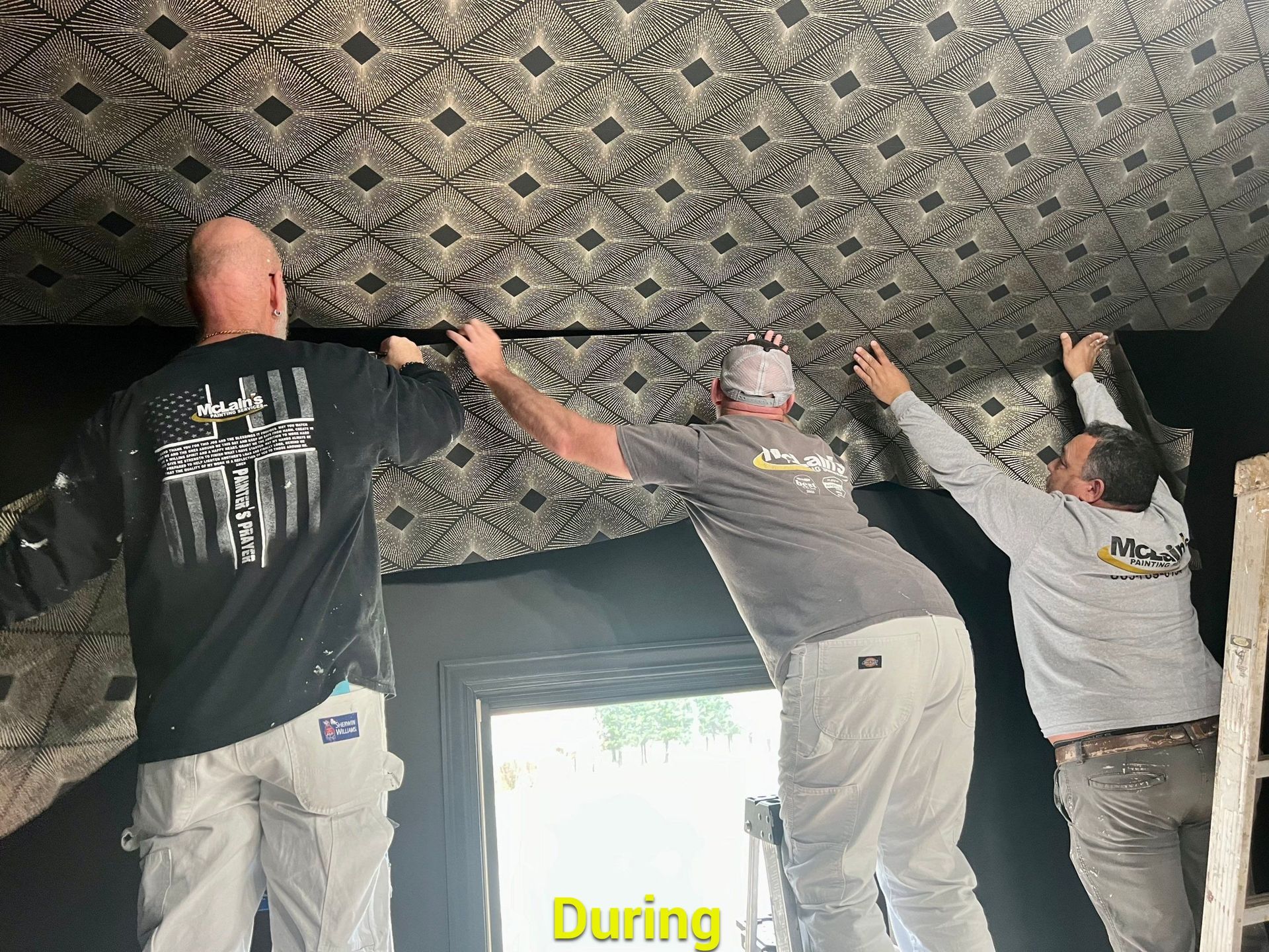 Three men are working on a ceiling in a room.