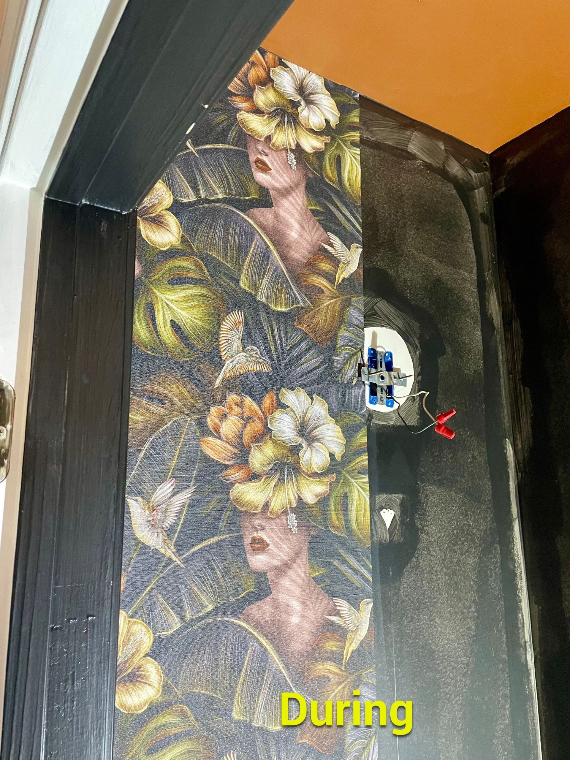 A painting of a woman with flowers on her head is on a wall.