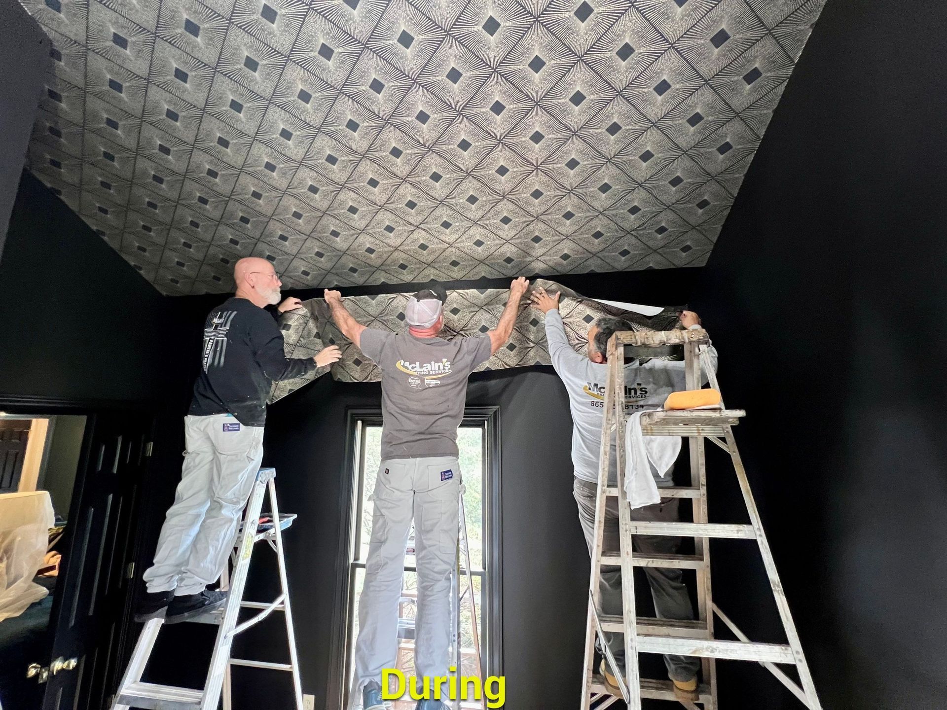 A group of men are working on a ceiling in a room.