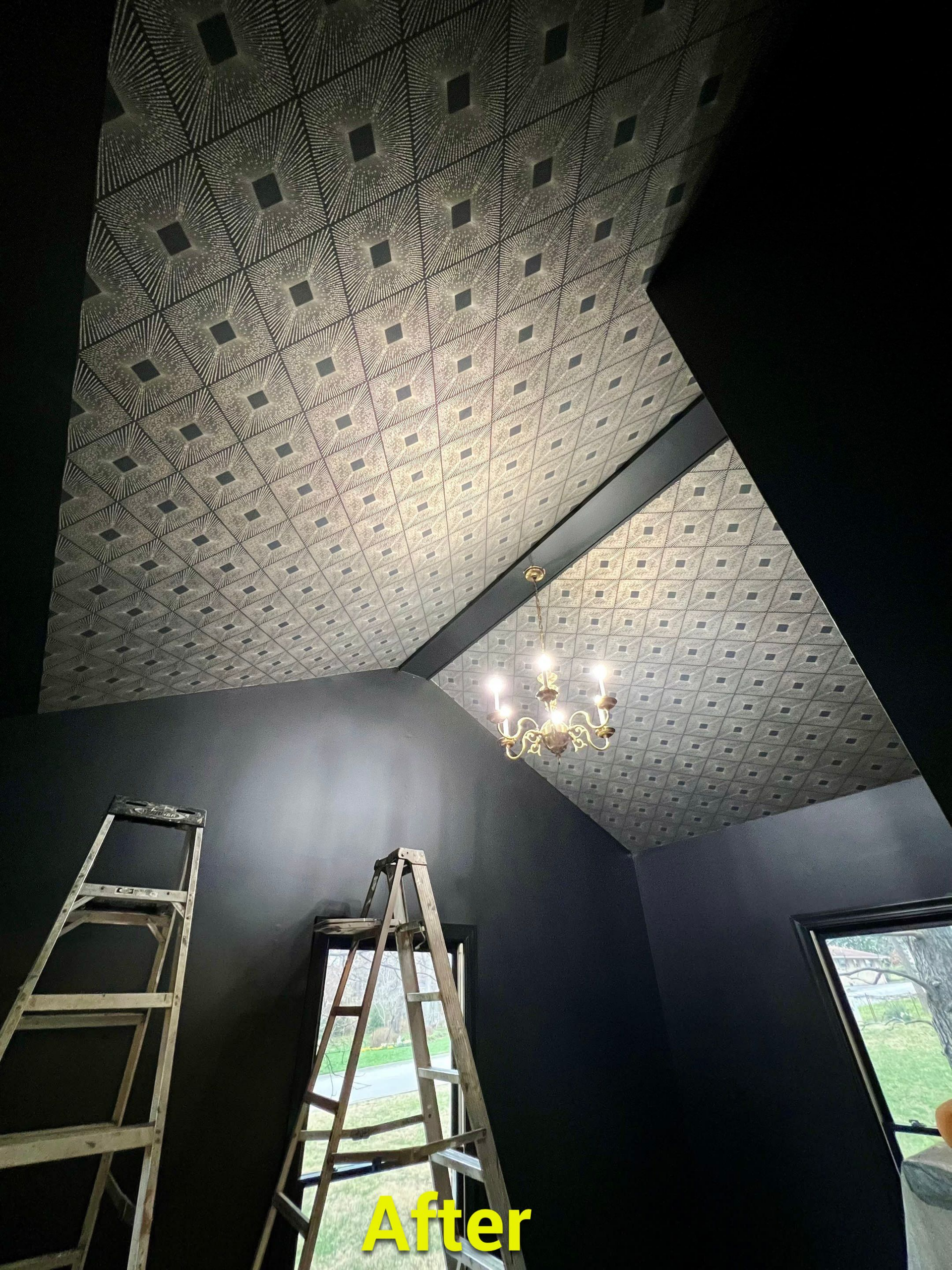 A room with a ladder and a chandelier on the ceiling.