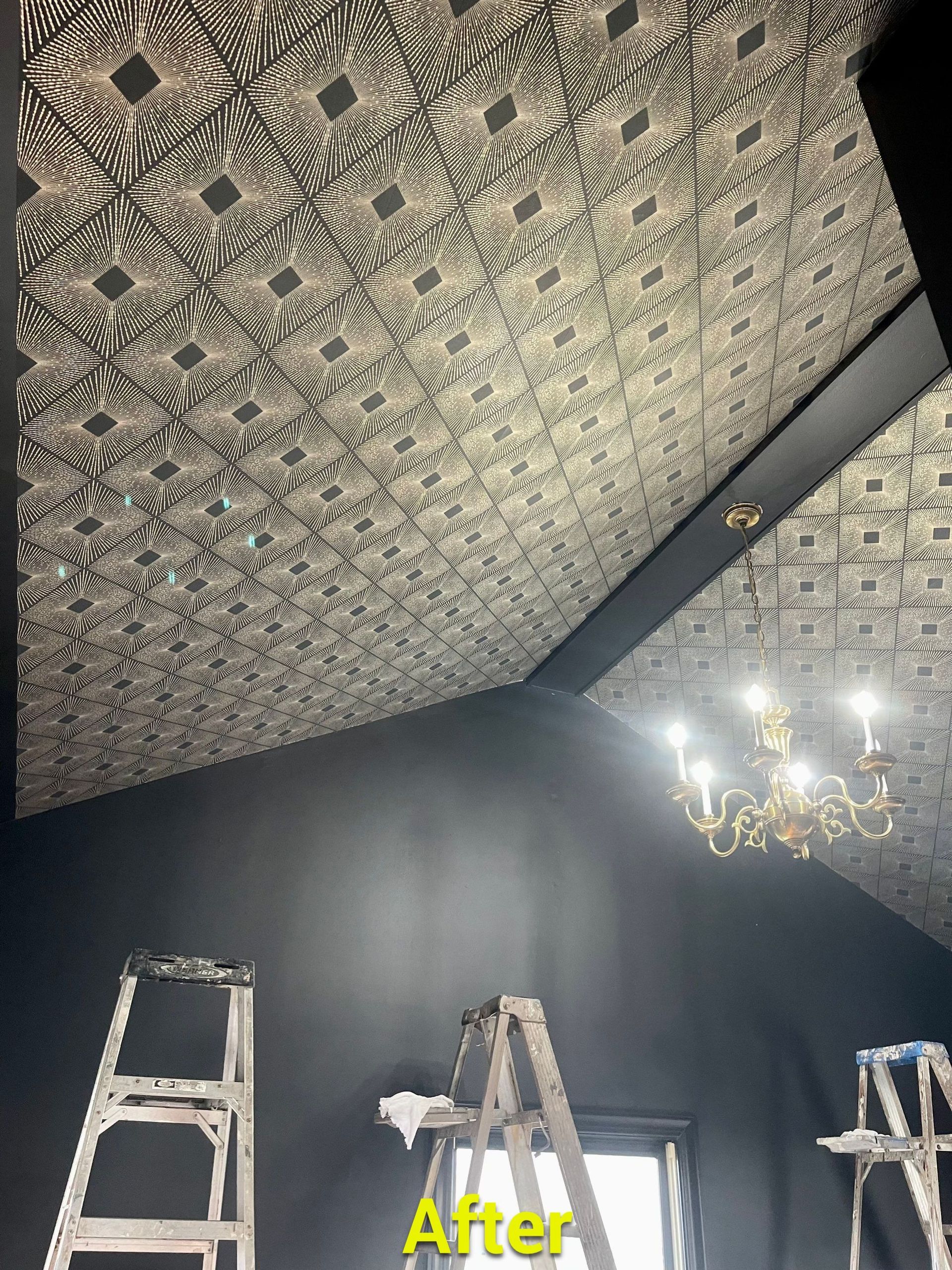 A picture of a ceiling with a pattern and a chandelier.