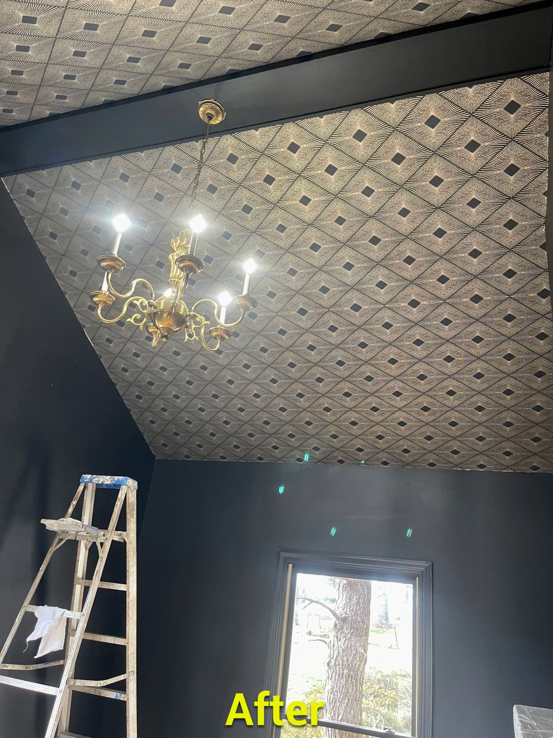 A room with a ladder and a chandelier on the ceiling.