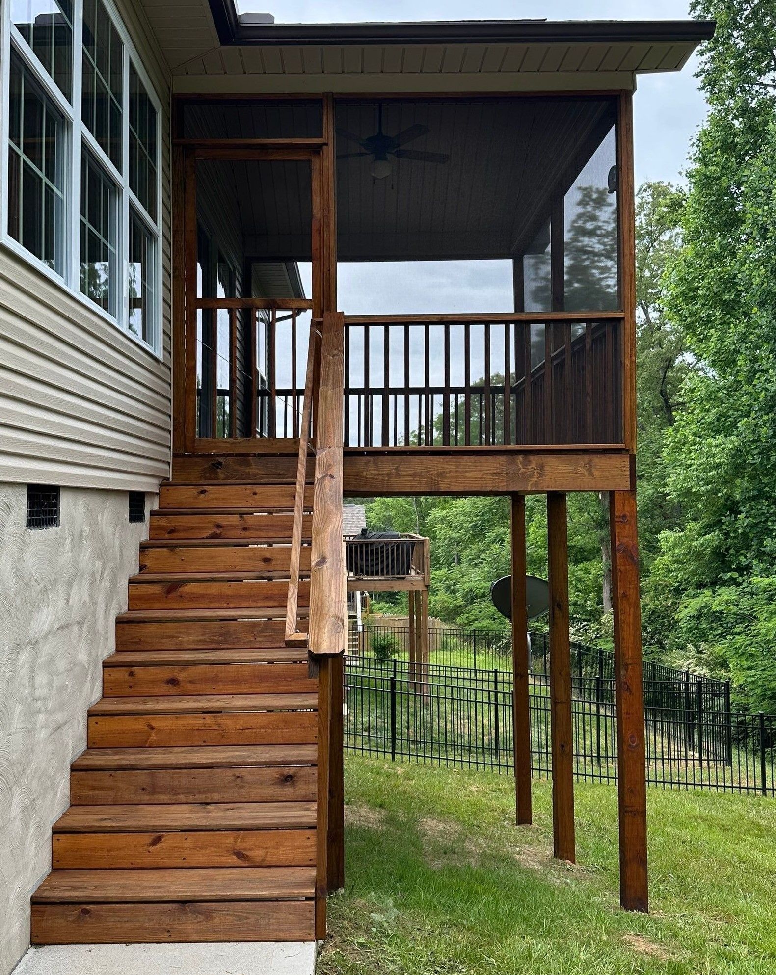 A screened in porch with stairs leading up to it.