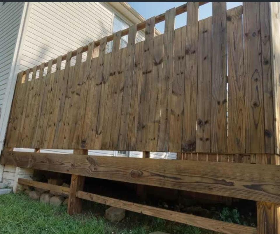 A wooden fence with a white house in the background