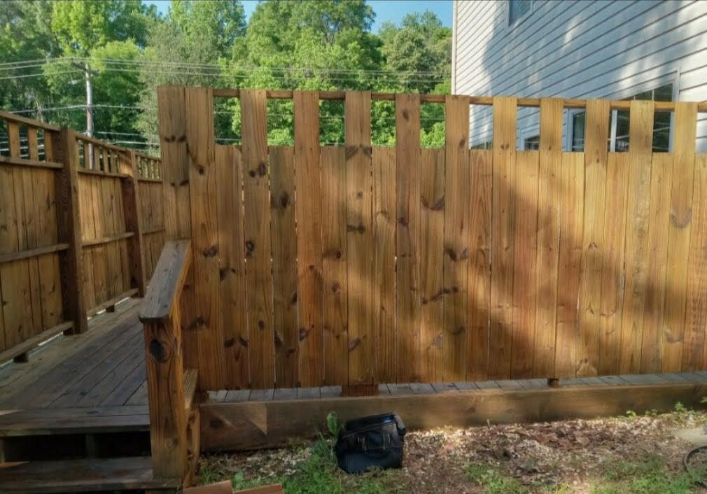 A wooden fence with a ramp in the backyard of a house.