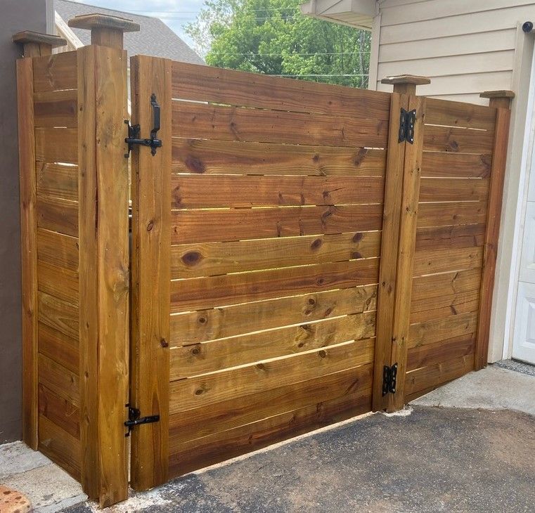 A wooden fence is sitting next to a garage door.