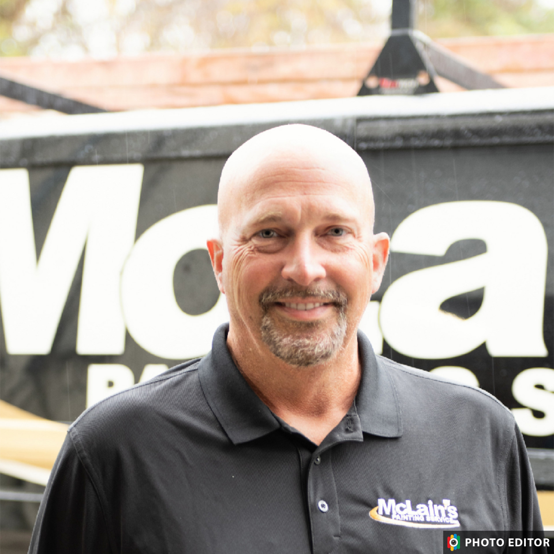 A man is standing in front of a mcla painting van