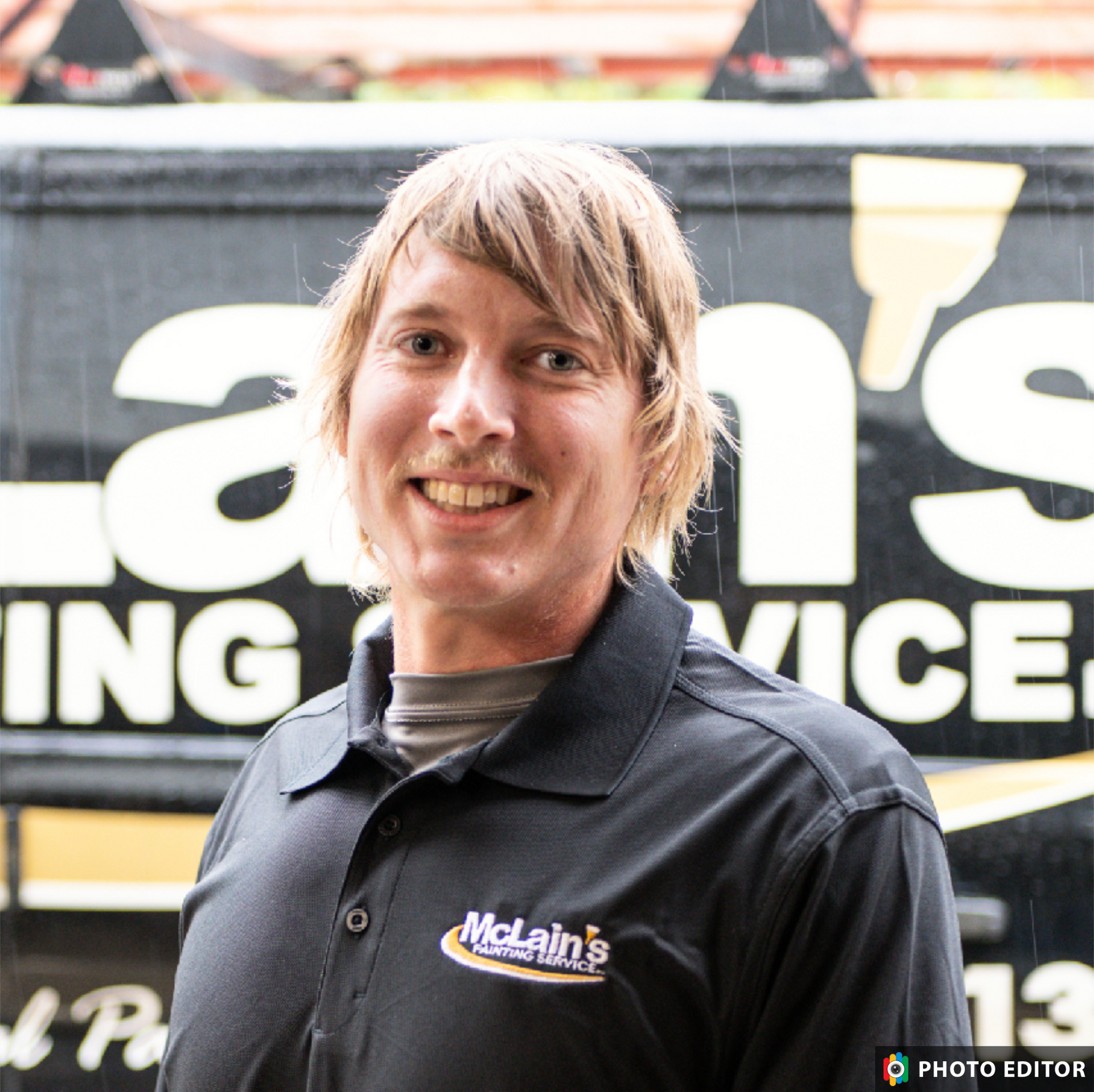 A man is standing in front of a mcla painting van