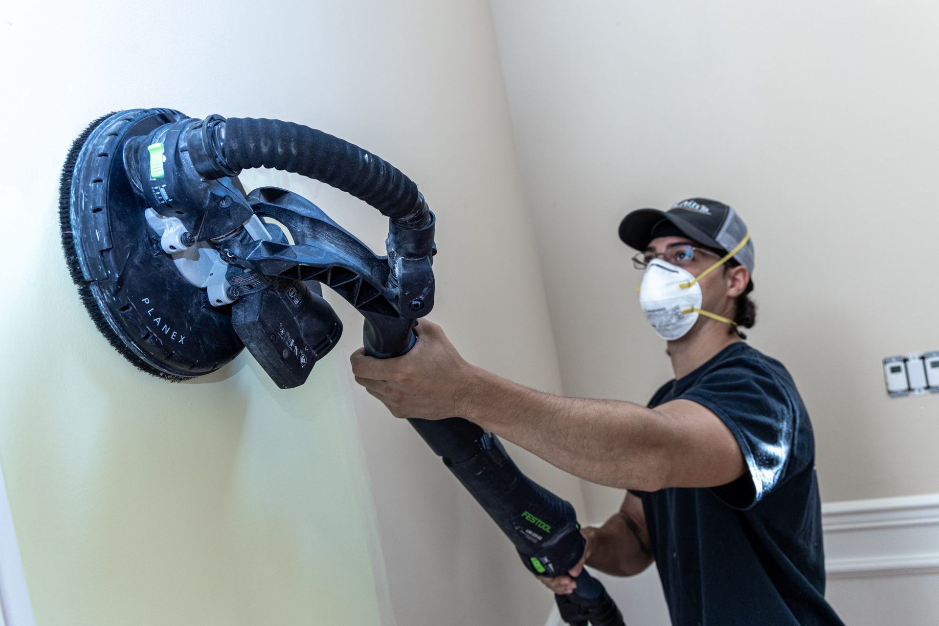 McLains Painting employee preps wall before paint