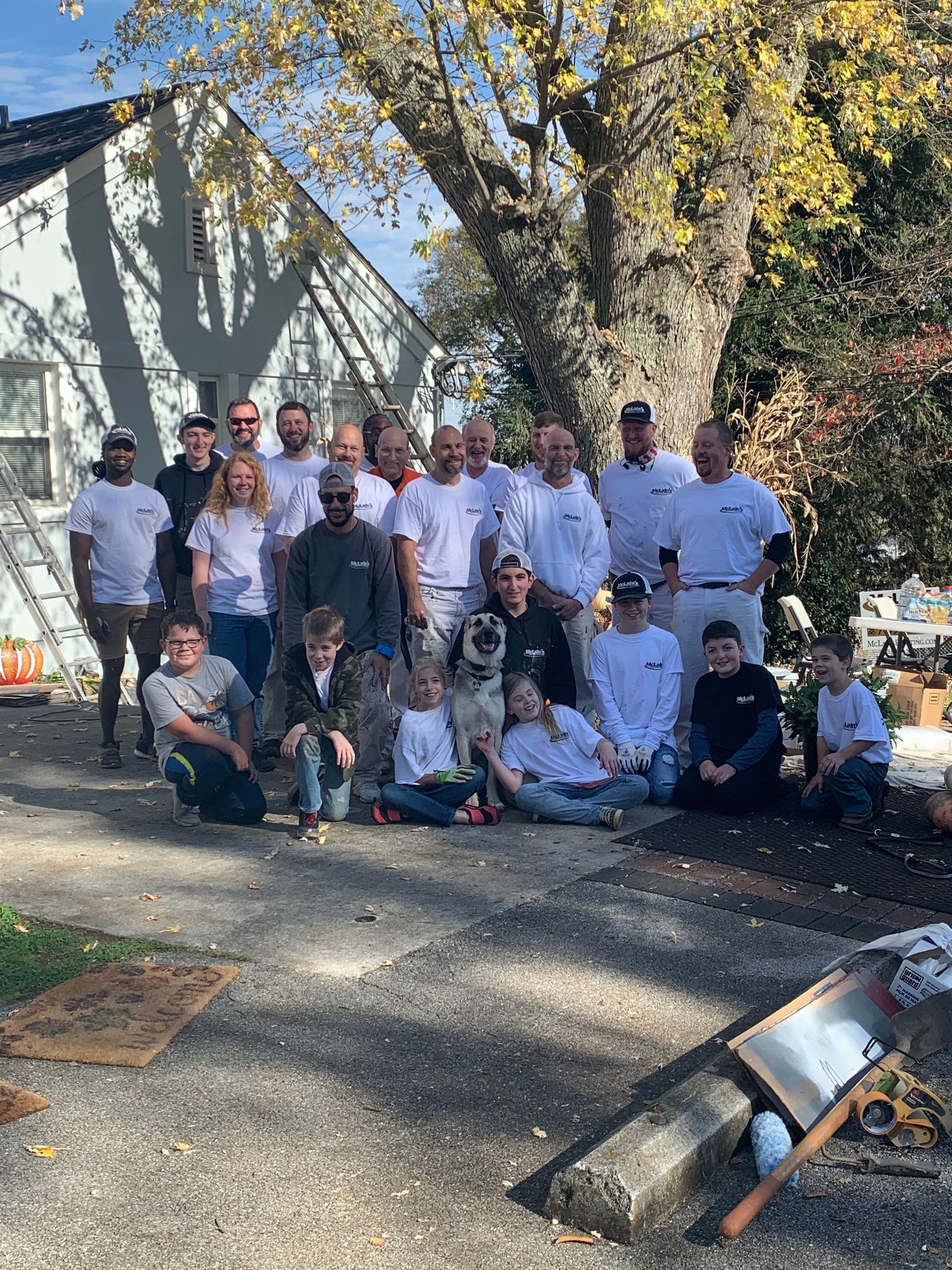 A group of people are posing for a picture in front of a house.