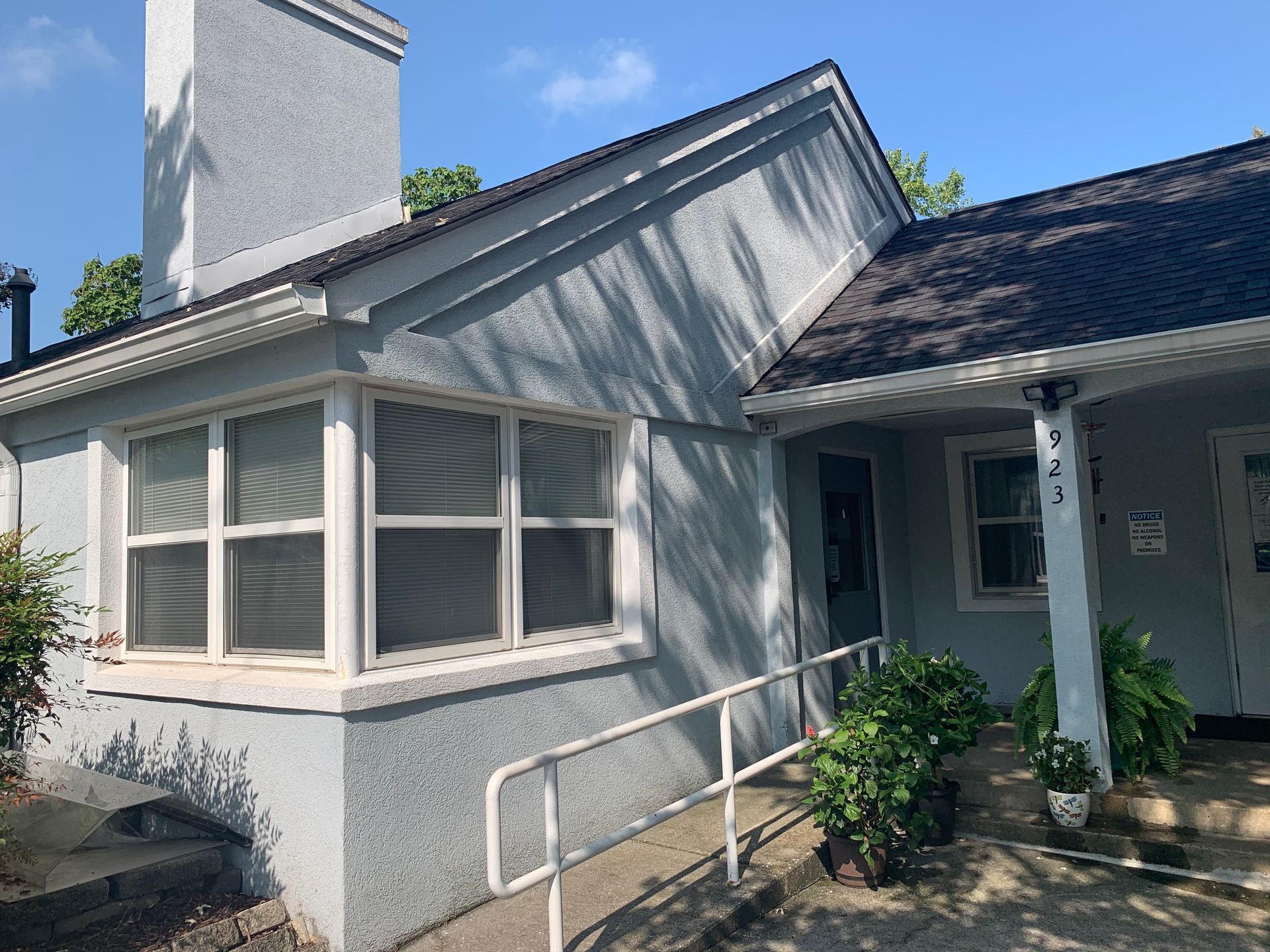 A house with a ramp and stairs leading to the front door.
