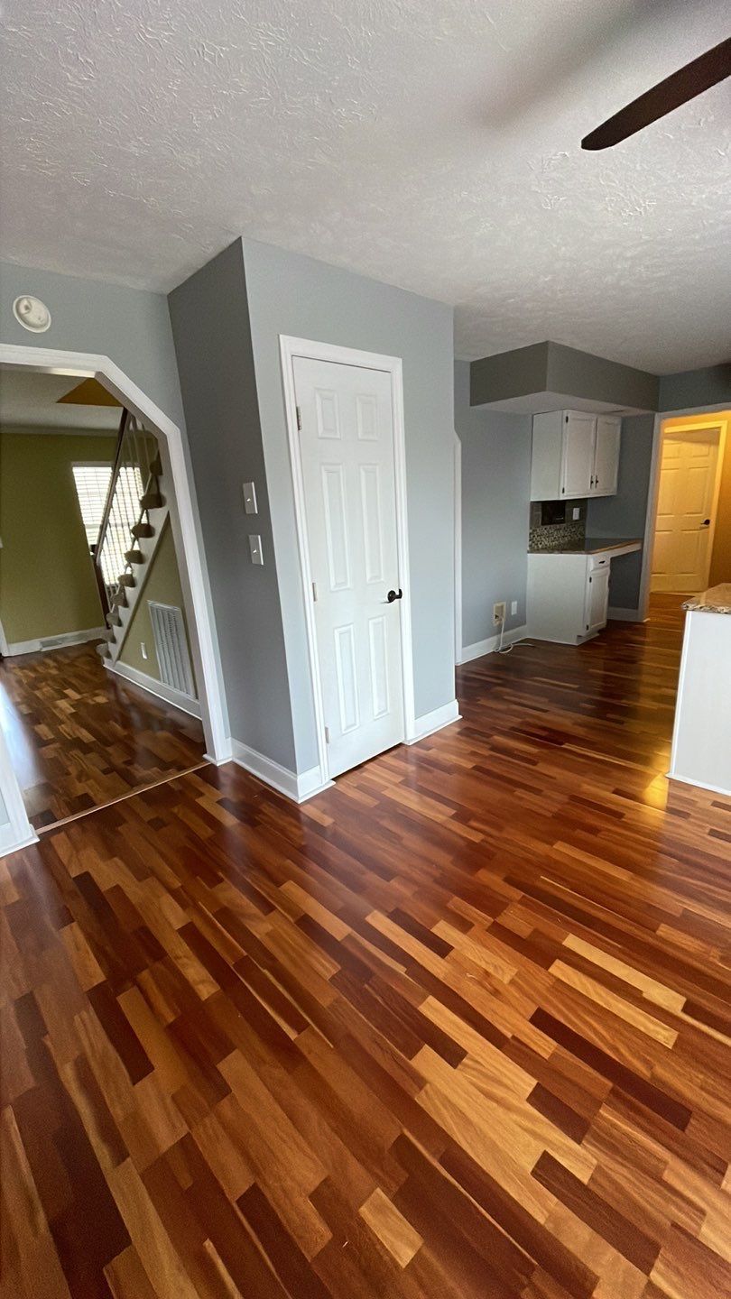 A living room with hardwood floors and a ceiling fan.