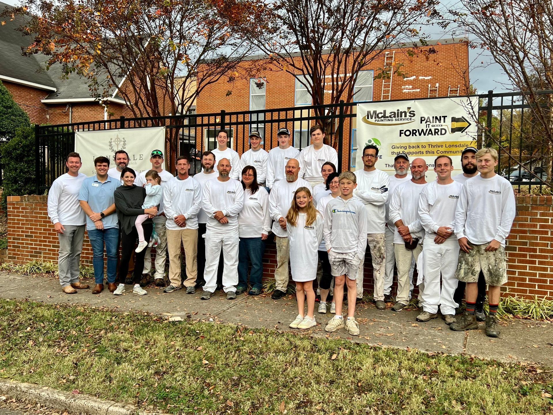 A group of people are posing for a picture in front of a building.