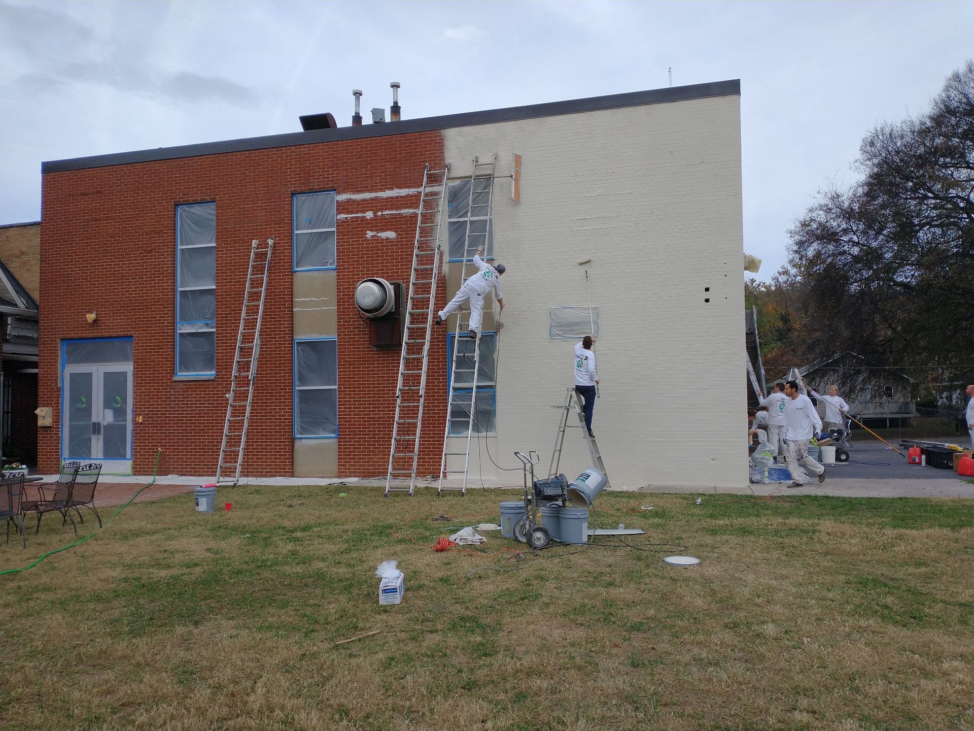 A group of people are painting the side of a building