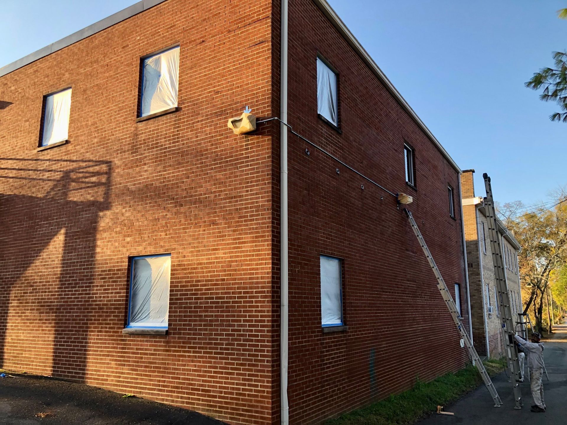 A brick building with a ladder on the side of it.
