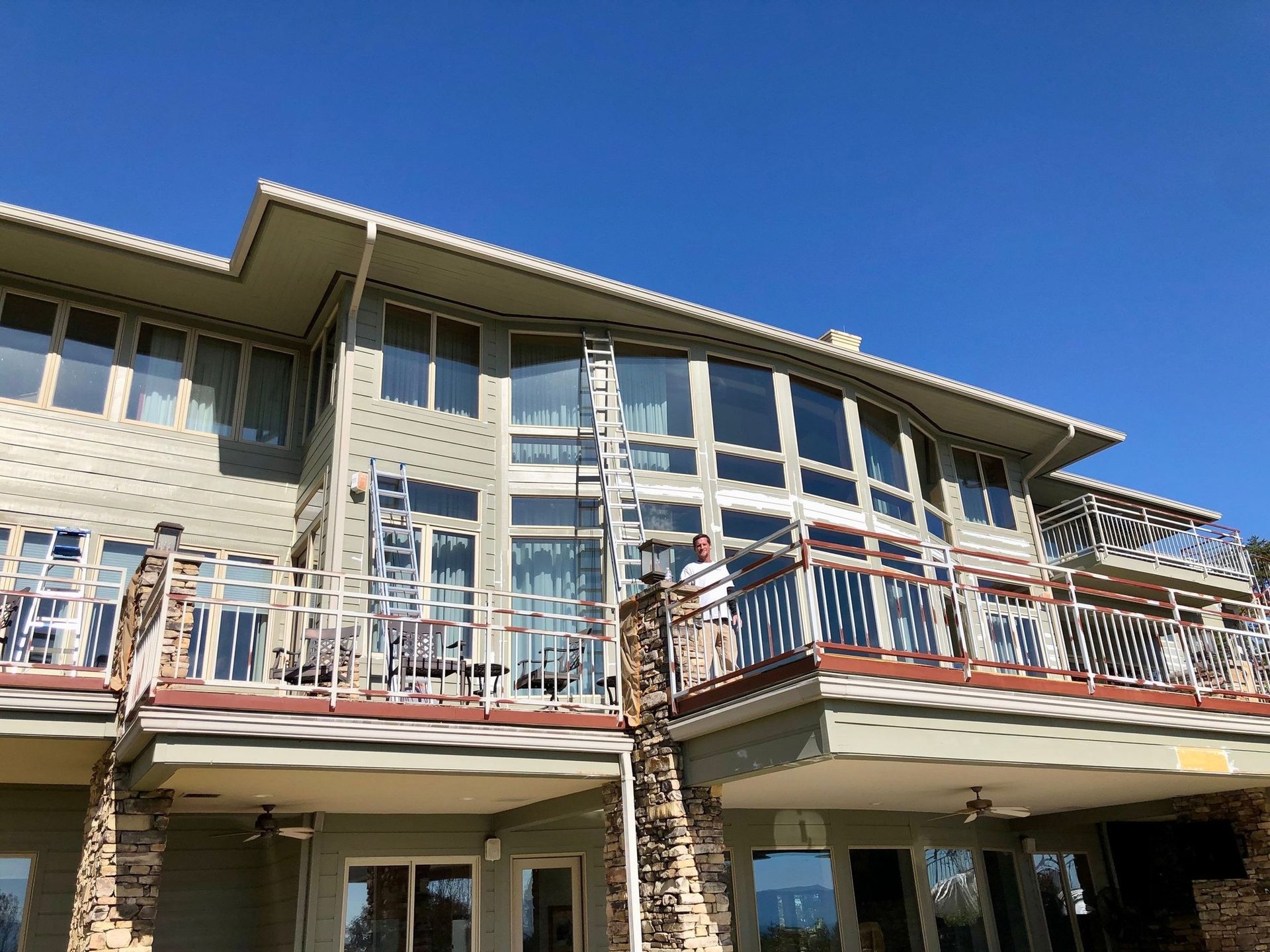 A wooden deck with a railing and stairs next to a house.