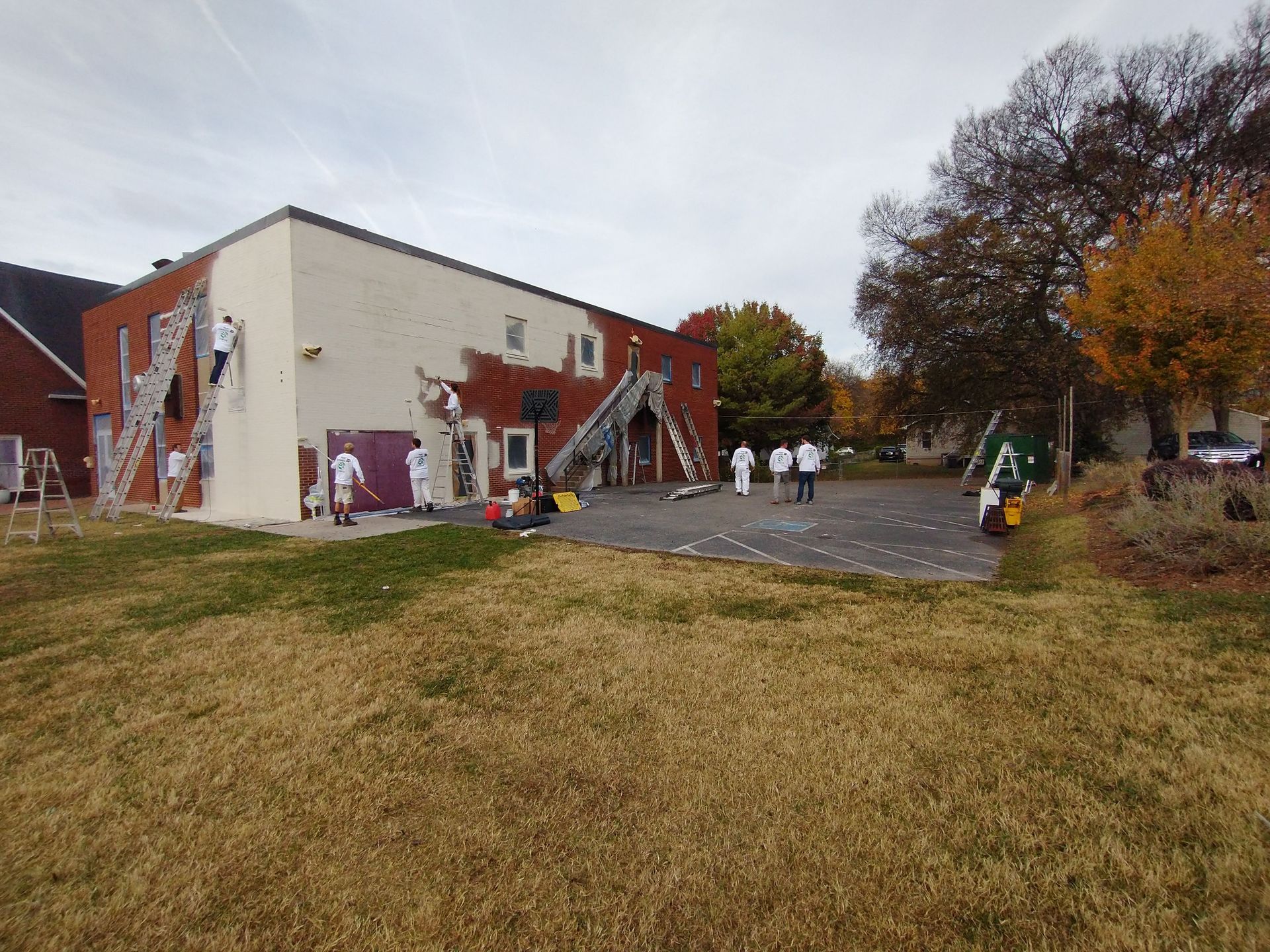 A group of people are painting the side of a building.