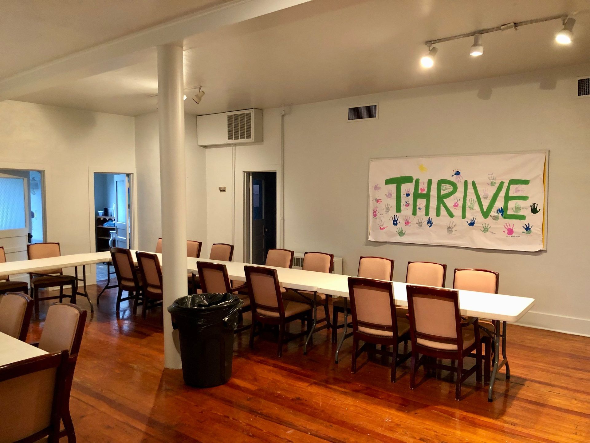 A room with tables and chairs and a sign that says thrive