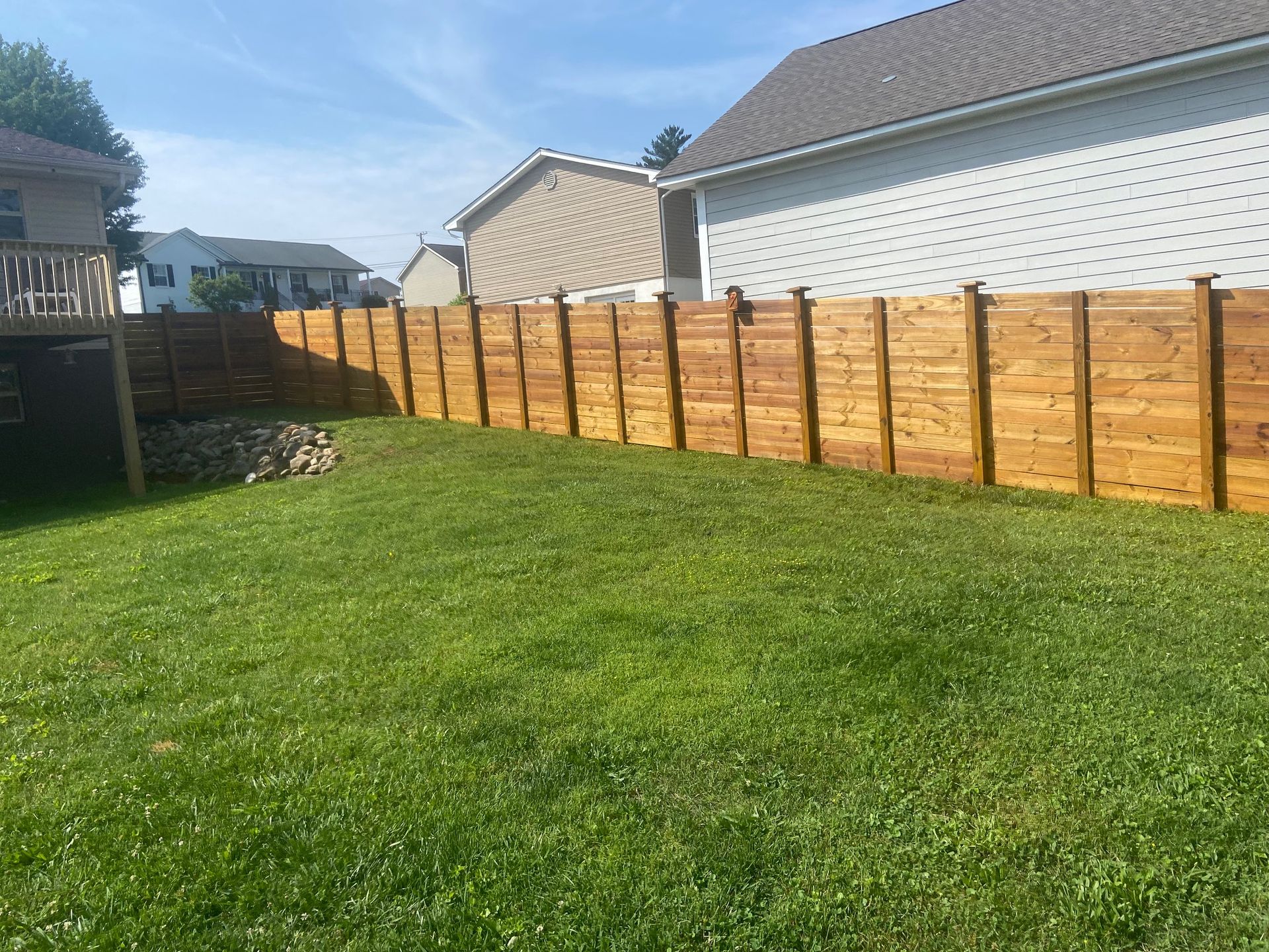 There is a wooden fence in the backyard of a house.