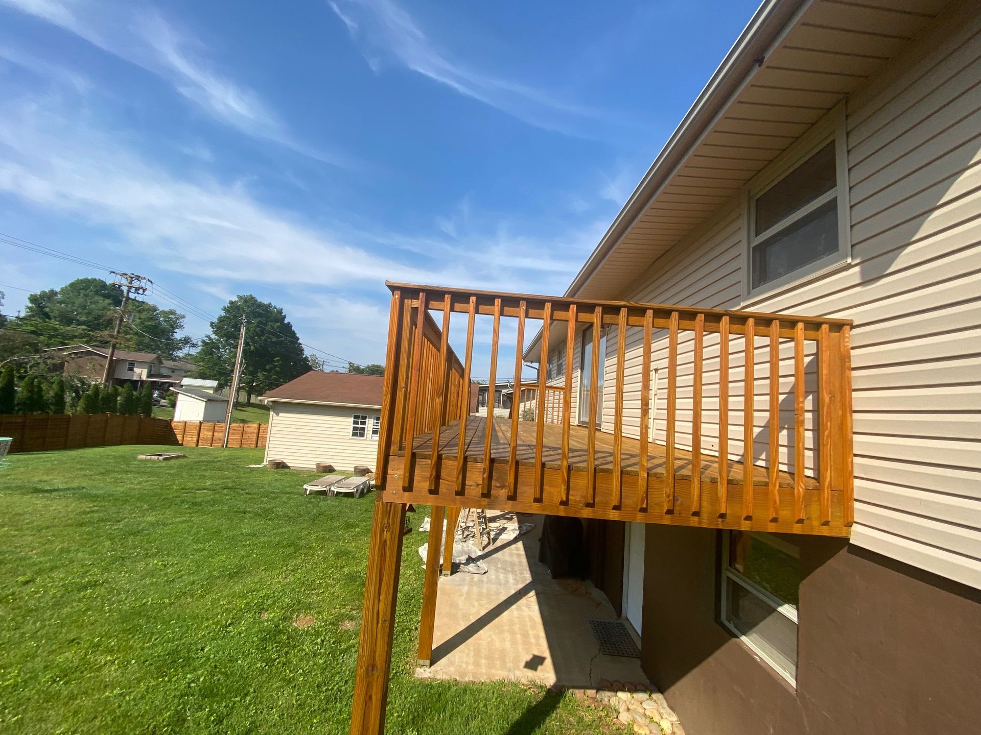 A house with a wooden deck in the backyard.