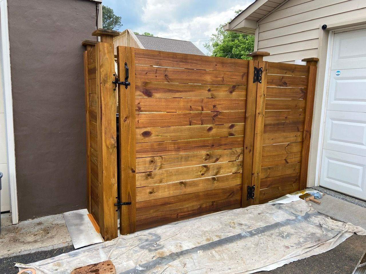 A wooden fence is sitting next to a garage door.