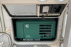 A green generator is sitting in the trunk of a truck.