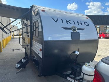 A viking trailer is parked in a parking lot next to a truck.