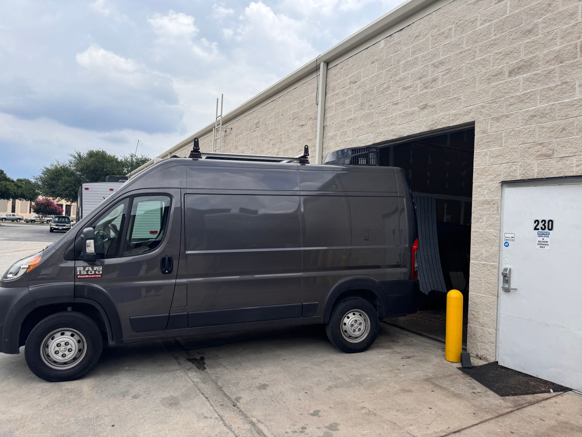 A gray van is parked in front of a building.